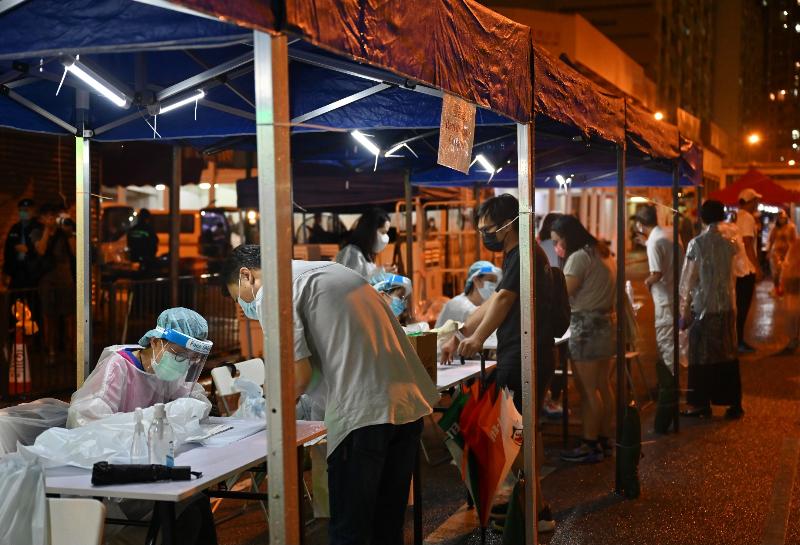 The Government yesterday (August 4) made a "restriction-testing declaration" and issued a compulsory testing notice in respect of the specified "restricted area" in Sham Shui Po (i.e. Block A, Tung Lo Court, 136-154 Tai Po Road, Sham Shui Po (excluding shops at the G/F level of shopping arcade, Tung Lo Court)), under which people within the specified "restricted area" in Sham Shui Po were required to stay in their premises and undergo compulsory testing. Photo shows staff members registering persons subject to compulsory testing in the "restricted area" to undergo testing.
