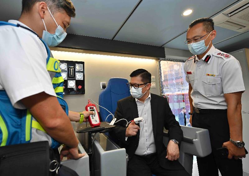 The Secretary for Security, Mr Tang Ping-keung (centre), visited the Tsim Tung Fire Station today (August 9) to inspect its equipment for fire and ambulance services and learned how the Fire Services Department utilises technology to enhance emergency services. Photo shows Mr Tang trying an equipment to safeguard the health of frontline personnel on "Work Rest 15", a vehicle for the frontline personnel to take brief rest after carrying out firefighting and rescue operation at fire scenes.