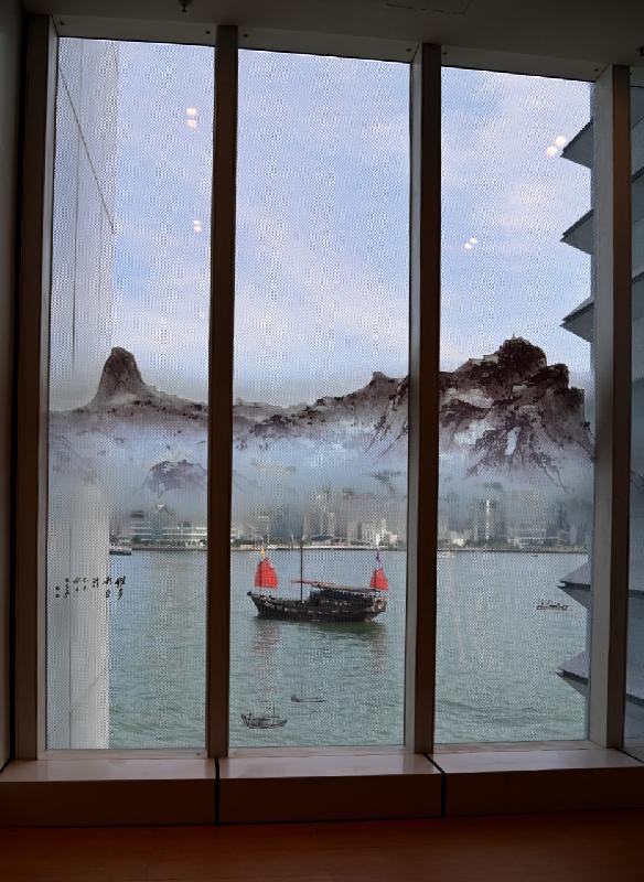 香港藝術館明日（八月十三日）起舉行「藝術要有形——呂壽琨的尋禪之道」展覽。圖示展廳外玻璃窗貼上呂壽琨以筆墨描繪六十年代維多利亞港的圖像，與真實的維港景致相映成趣。參觀者亦可掃描二維碼，在照片添加展覽特設的小船移動效果。