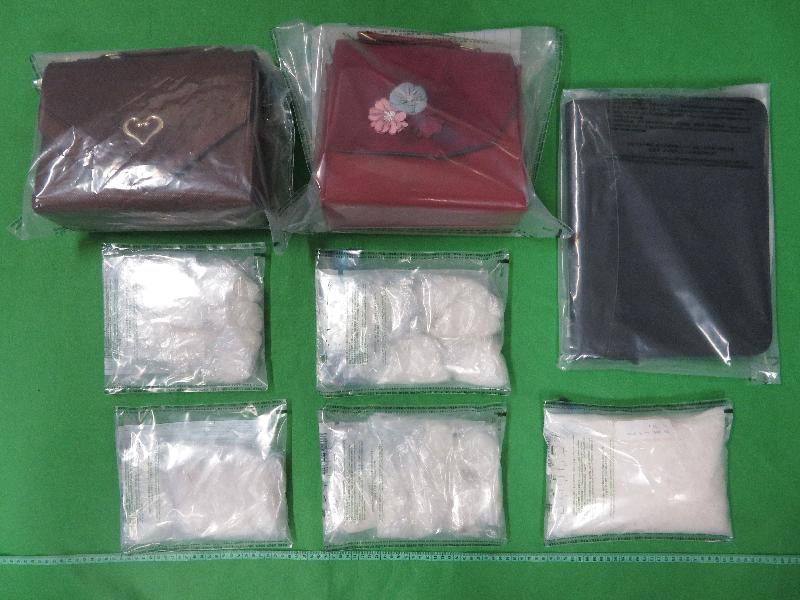 Hong Kong Customs yesterday (September 24) arrested three men, aged between 26 and 28, suspected to be connected with four drug trafficking cases through the air cargo channel of which a total of about 8.8 kilograms of suspected methamphetamine and about 3.7kg of suspected ketamine with an estimated market value of about $8 million were seized at Tsing Yi and Hong Kong International Airport. Photo shows some of the suspected methamphetamine seized and the file folder and handbags used to conceal the drugs.