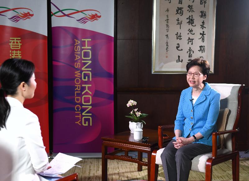 The Chief Executive, Mrs Carrie Lam (right), gives an interview to the local media in Chongqing today (September 25).