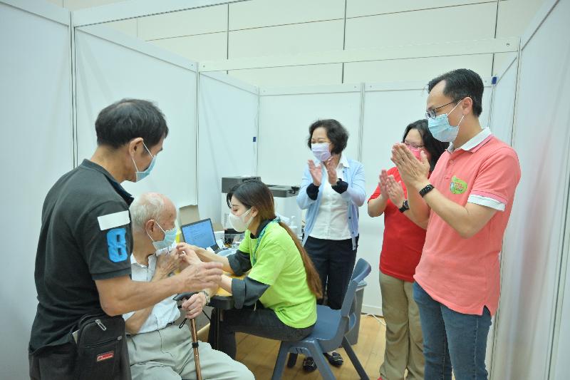 Elderly persons from the Kowloon City District participated in a COVID-19 vaccination event for the elderly at Hung Hom Community Hall today (October 2). Photo shows a senior citizen receiving the Sinovac vaccine after the health talk. Looking on is the Secretary for the Civil Service, Mr Patrick Nip (first right).