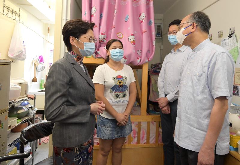 The Chief Executive, Mrs Carrie Lam, today (October 10) visited transitional housing projects operated by the Lok Sin Tong Benevolent Society, Kowloon. Photo shows Mrs Lam (first left), accompanied by the Secretary for Transport and Housing, Mr Frank Chan Fan (first right), visiting a family to learn more about their living situation.
