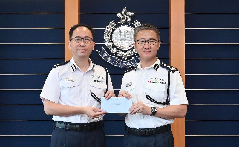 The newly appointed Deputy Commandant of the Hong Kong Auxiliary Police Force, Mr Johnny Leung Sai-kwong (left), receives the appointment letter from the Commissioner of Police, Mr Siu Chak-yee (right).