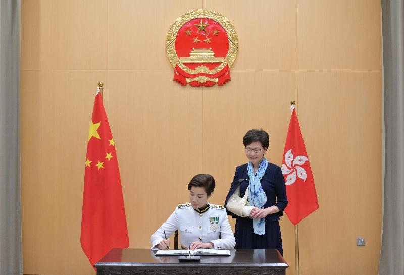 The new Commissioner of Customs and Excise, Ms Louise Ho (left), signs the oaths after her swearing-in today (October 21).
