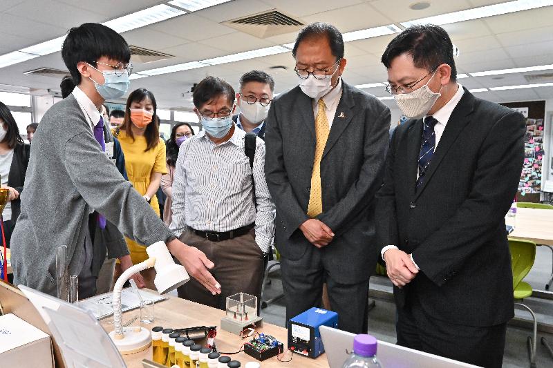 The Secretary for Innovation and Technology, Mr Alfred Sit (first right); the Chairman of the Vetting Committee on IT Innovation Lab Programme in Schools, Professor Wong Kam-fai (second right); and committee members Mr Leonard Chan (third right) and Dr Wong Chung-kiu (fourth right) chat with students on their learning experience of utilising environmentally friendly materials to create a chlorine generator in a visit to Man Kwan Pak Kau College today (October 21).