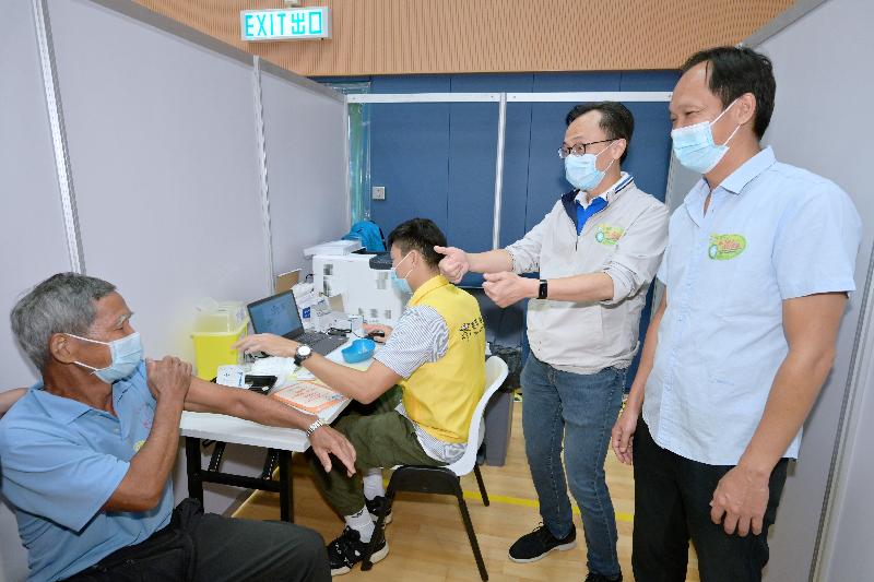 The Government's outreach COVID-19 vaccination team went to Islands District today (October 30) to serve residents in Mui Wo and Peng Chau. Photo shows a senior citizen receiving the Sinovac vaccine in the vaccination activity in Mui Wo Sports Centre. Looking on is the Secretary for the Civil Service, Mr Patrick Nip (second right).

