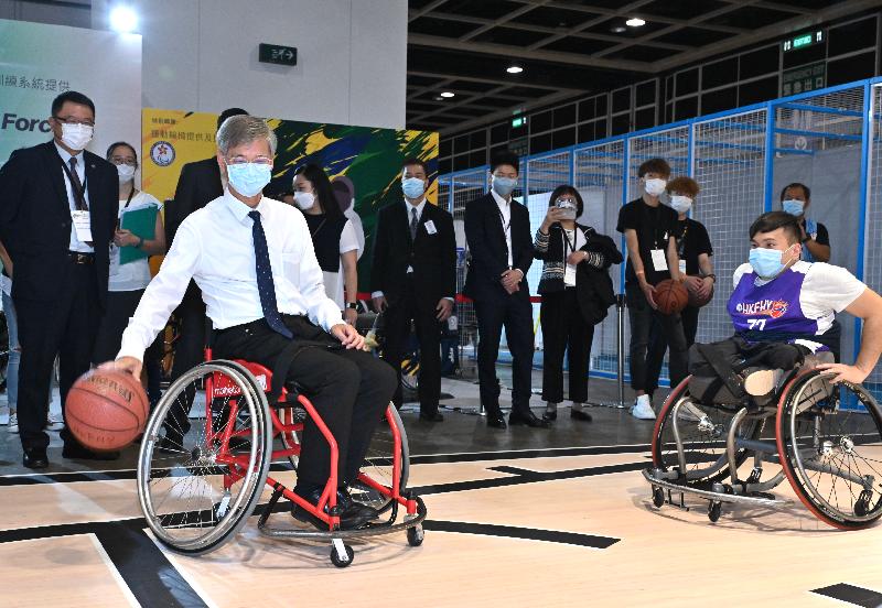 The Secretary for Labour and Welfare, Dr Law Chi-kwong, today (November 3) officiated at the opening ceremony of the Gerontech and Innovation Expo cum Summit 2021 jointly hosted by the Government and the Hong Kong Council of Social Service. Photo shows Dr Law (left) in a wheelchair basketball game with a representative of the Hong Kong Federation of Handicapped Youth at the Interactive Sports Ground.