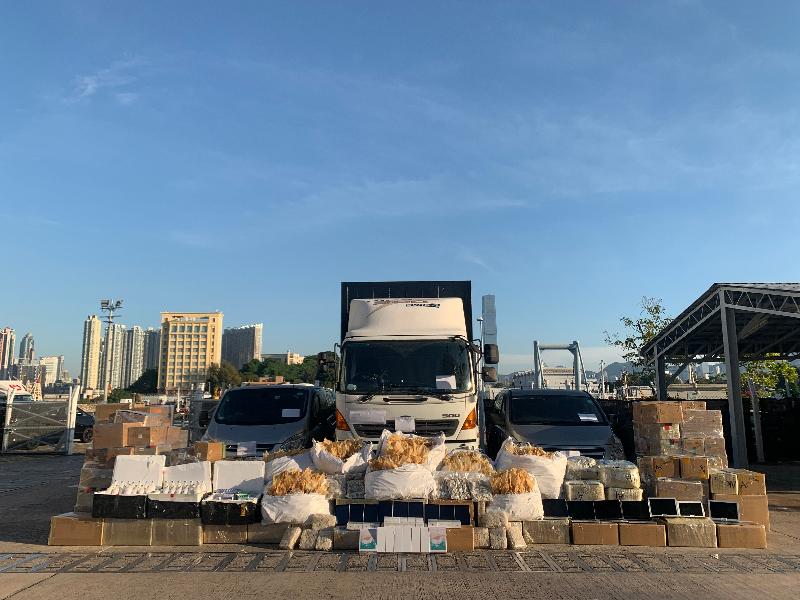Hong Kong Customs and the Marine Police mounted a joint anti-smuggling operation on November 13 and detected a suspected speedboat-related smuggling case in Tung Chung. A batch of suspected smuggled goods, including high-value food, electronic products and veterinary products, with an estimated value of about $21 million was seized. Photo shows the suspected smuggled goods seized and three vehicles suspected to be connected with the case being detained.