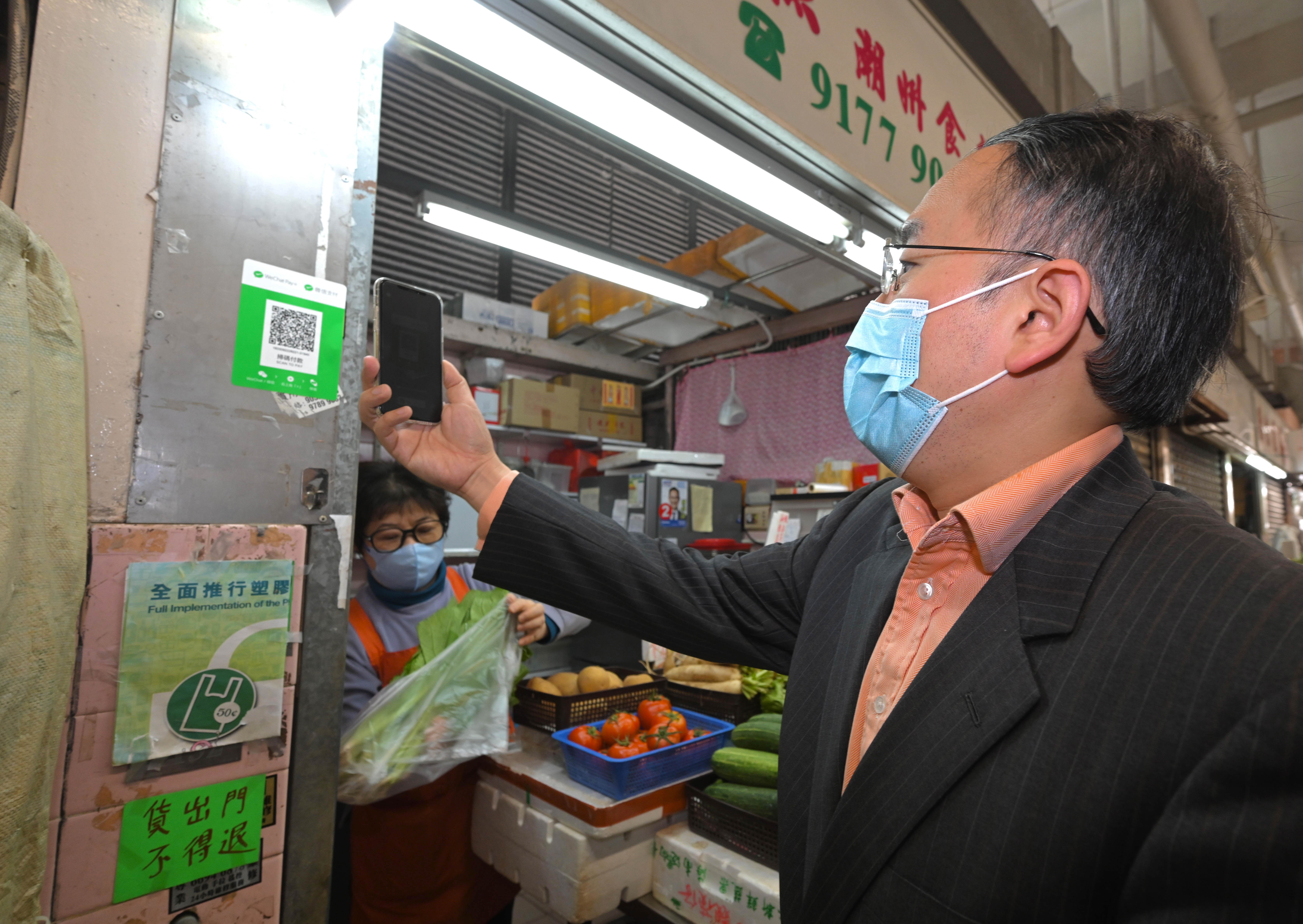 The Secretary for Financial Services and the Treasury, Mr Christopher Hui, today (November 25) visits several stalls at Smithfield Market and makes purchases with e-payment.