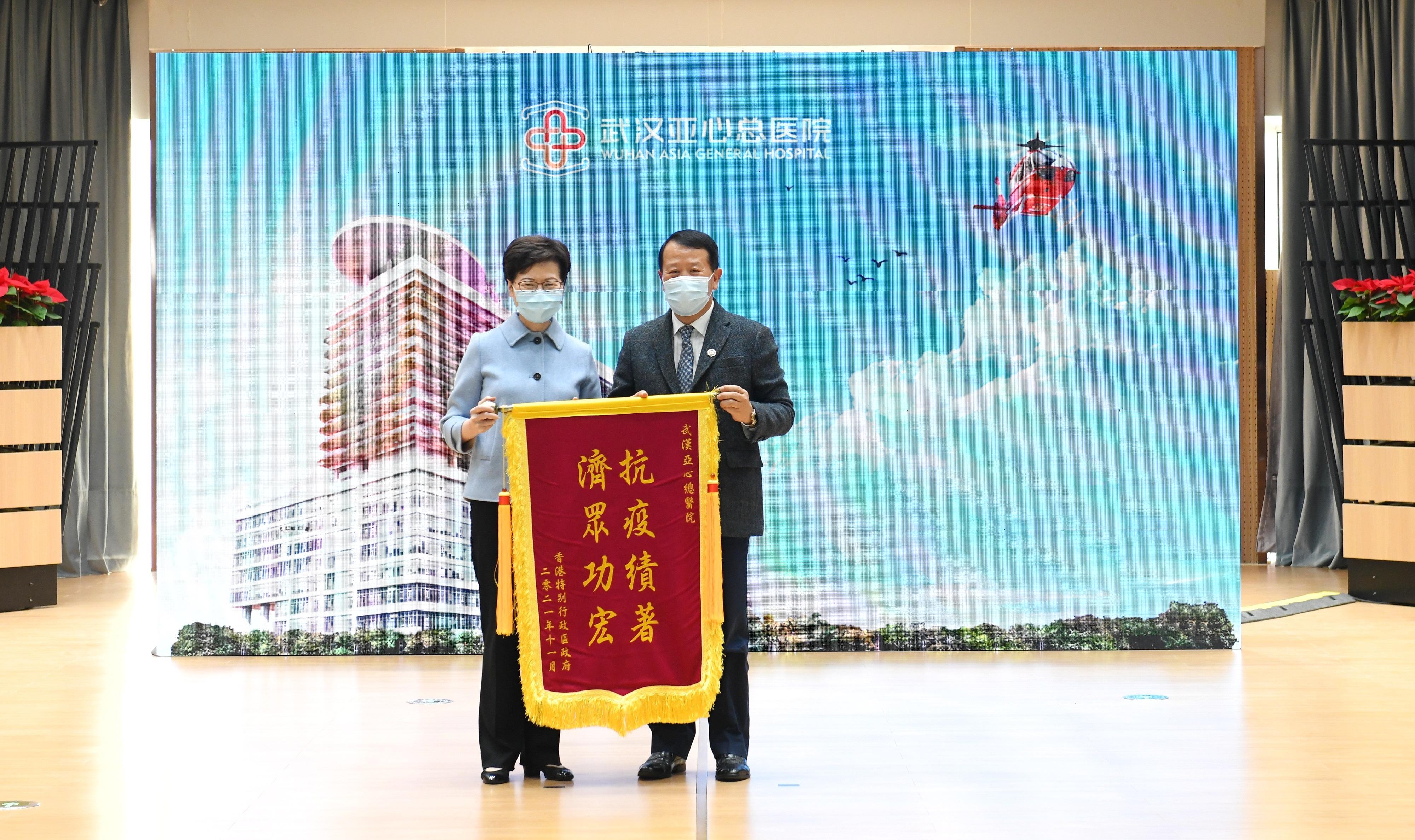 The Chief Executive, Mrs Carrie Lam, visited Wuhan Asia General Hospital, a Hong Kong enterprise, in Wuhan today (November 29). Photo shows Mrs Lam (left) presenting a flag of appreciation to the Chairman of Hong Kong Asia Medical Group, Mr Tse Chun-ming.