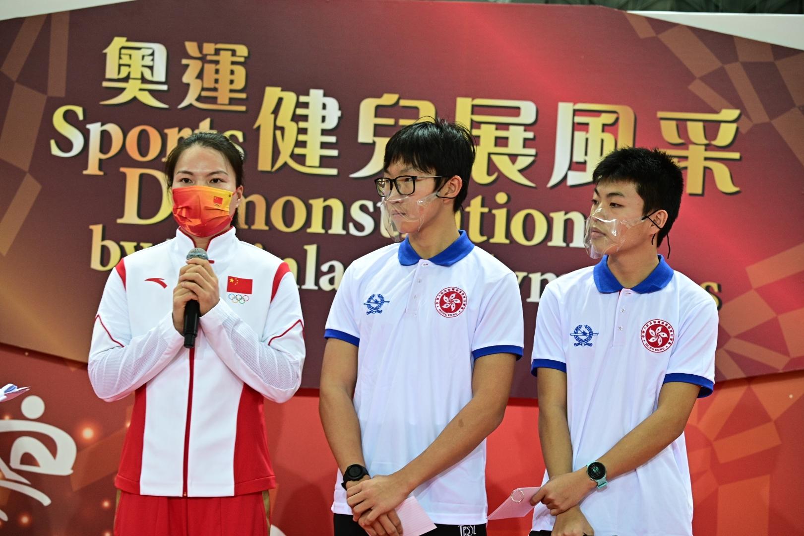 The delegation of Tokyo 2020 Olympic Games Mainland Olympians attended the sports demonstrations at Victoria Park Swimming Pool this morning (December 4). Photo shows Mainland canoe athlete Xu Shixiao (left) having a chat and skill exchange with local young athletes.