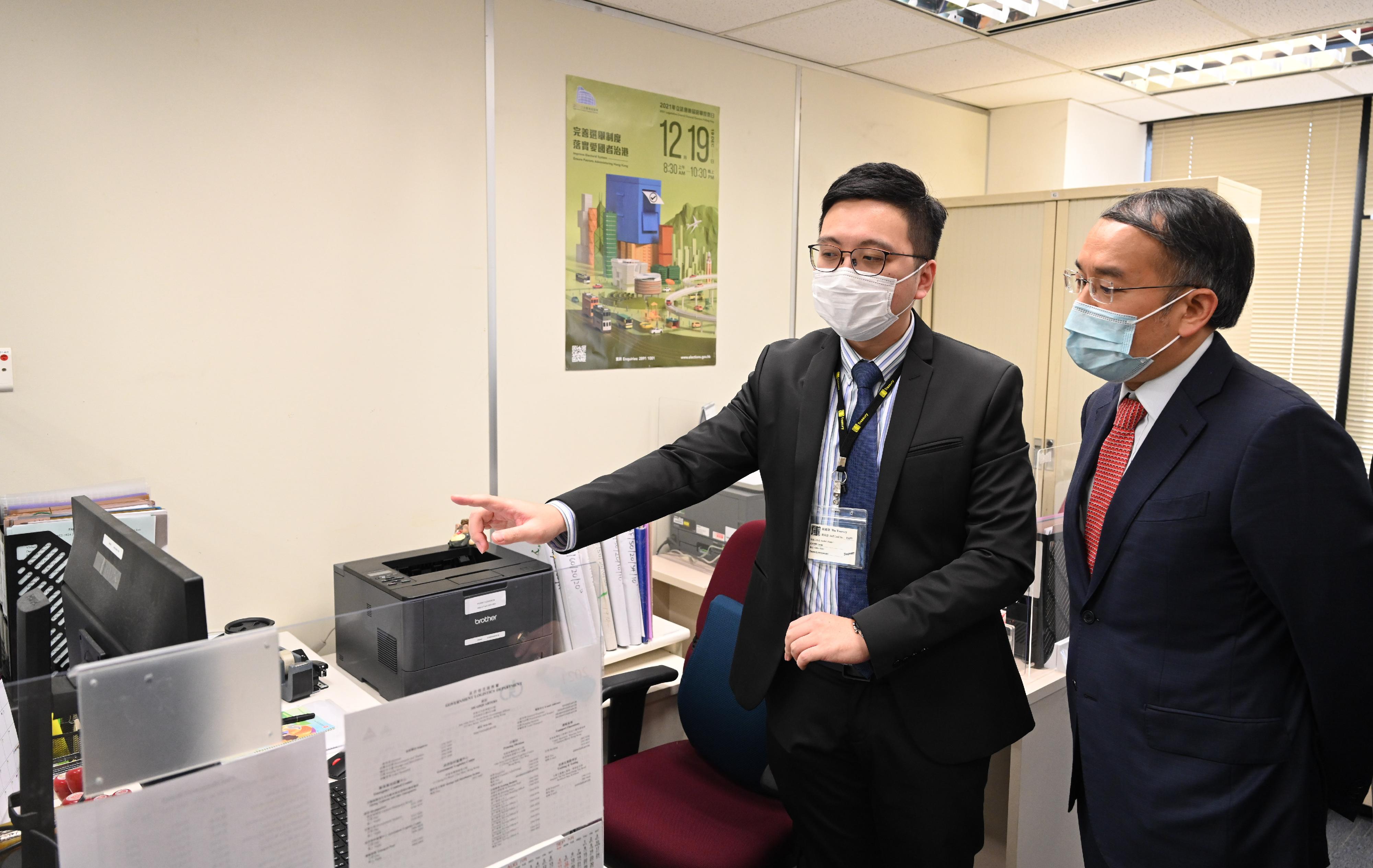 The Secretary for Financial Services and the Treasury, Mr Christopher Hui, visited the Treasury today (December 9). Photo shows Mr Hui (right) being briefed on the Treasury's work.