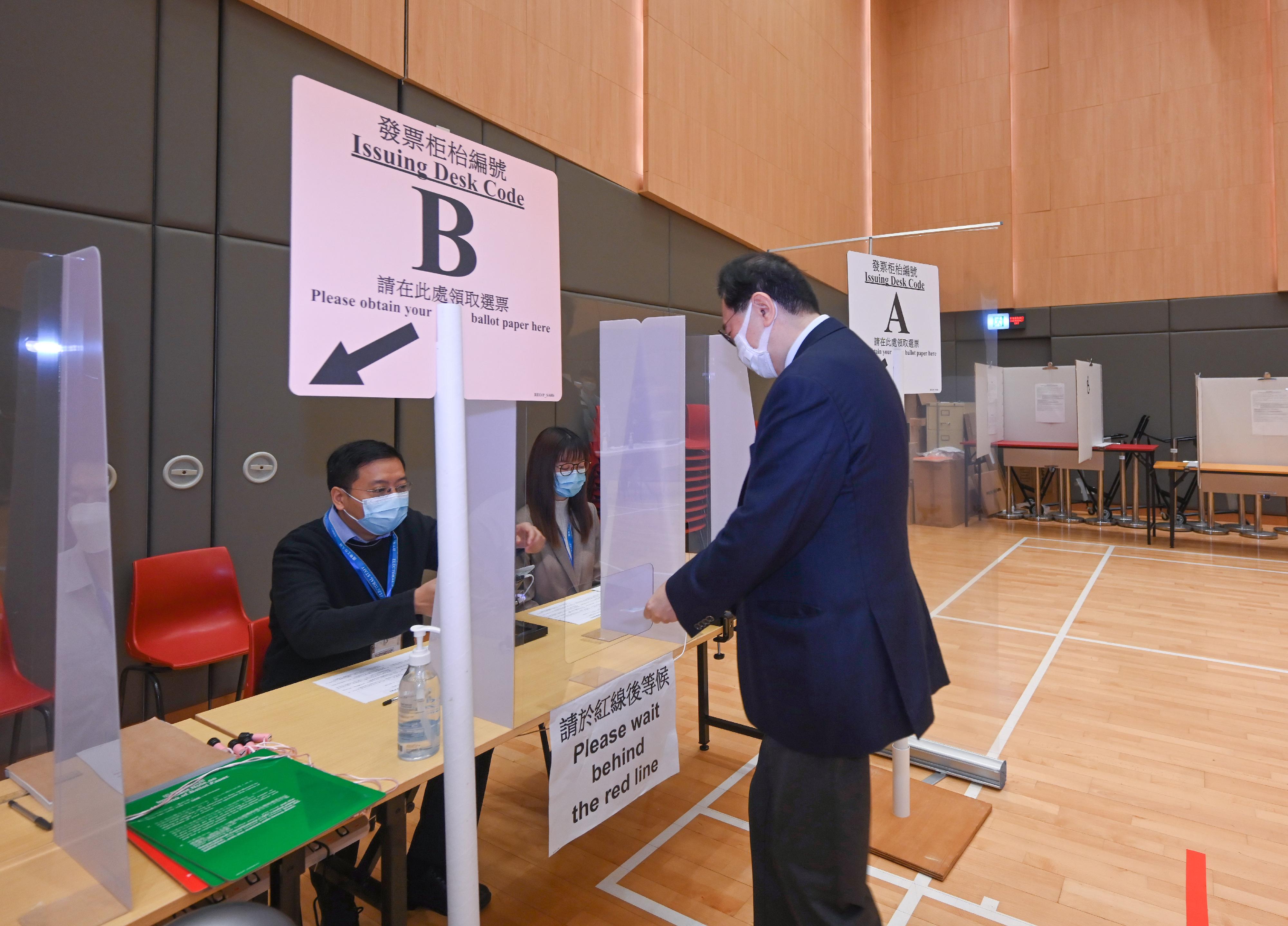 The Chairman of the Electoral Affairs Commission, Mr Justice Barnabas Fung Wah (first right), demonstrates the proper procedure to cast votes in the Legislative Council General Election during his visit to a mock polling station at the North Point Community Hall today (December 14).