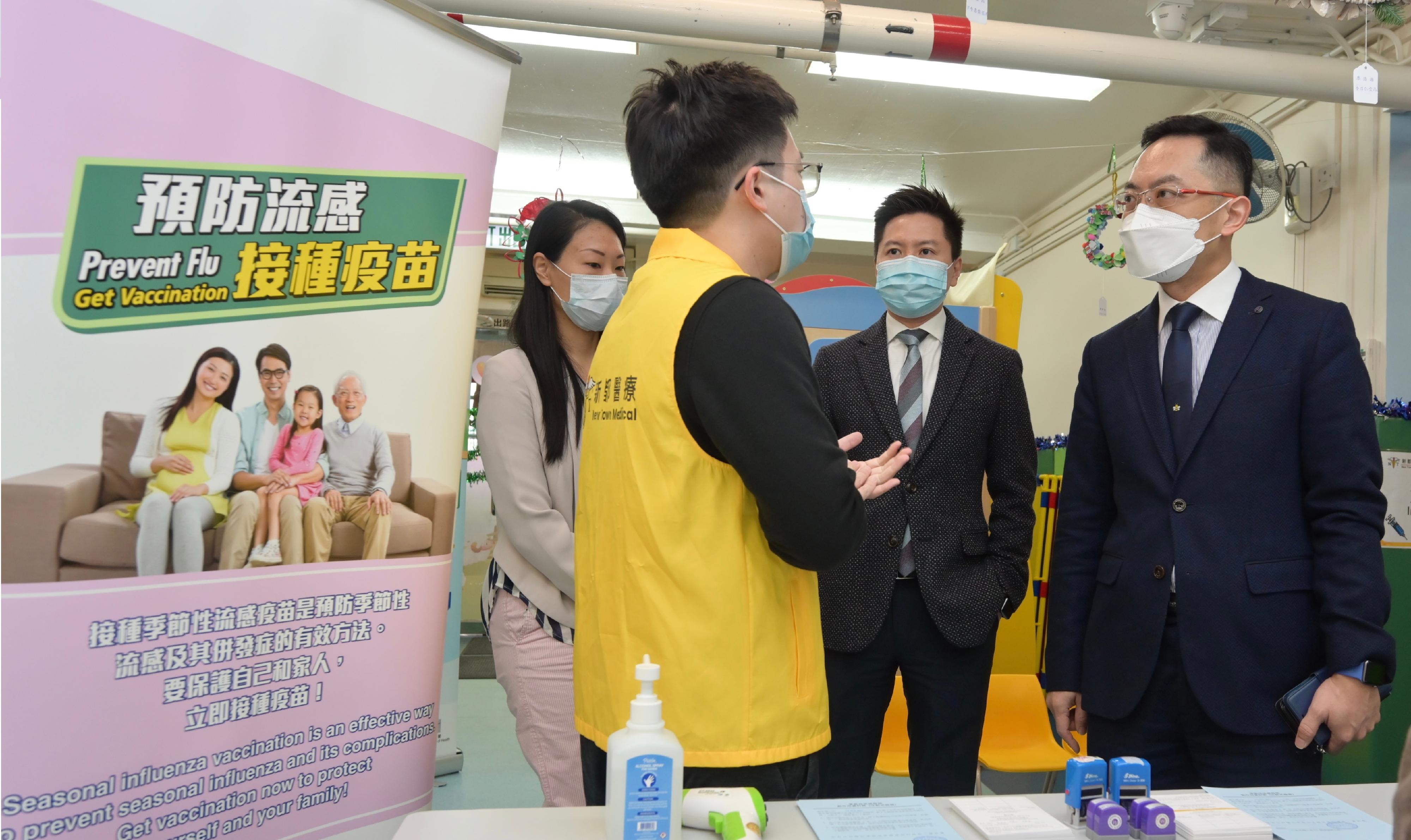The Director of Health, Dr Ronald Lam, and the Controller of the Centre for Health Protection of the Department of Health, Dr Edwin Tsui, this morning (December 15) visited St Thomas' Church Kindergarten in Shek Kip Mei to view the implementation of the school outreach seasonal influenza vaccination service. Photo shows Dr Lam (first right) and Dr Tsui (second right) chatting with a Public-Private-Partnership Team member (second left) providing the vaccination service to schoolchildren on-site to better understand the team's work.