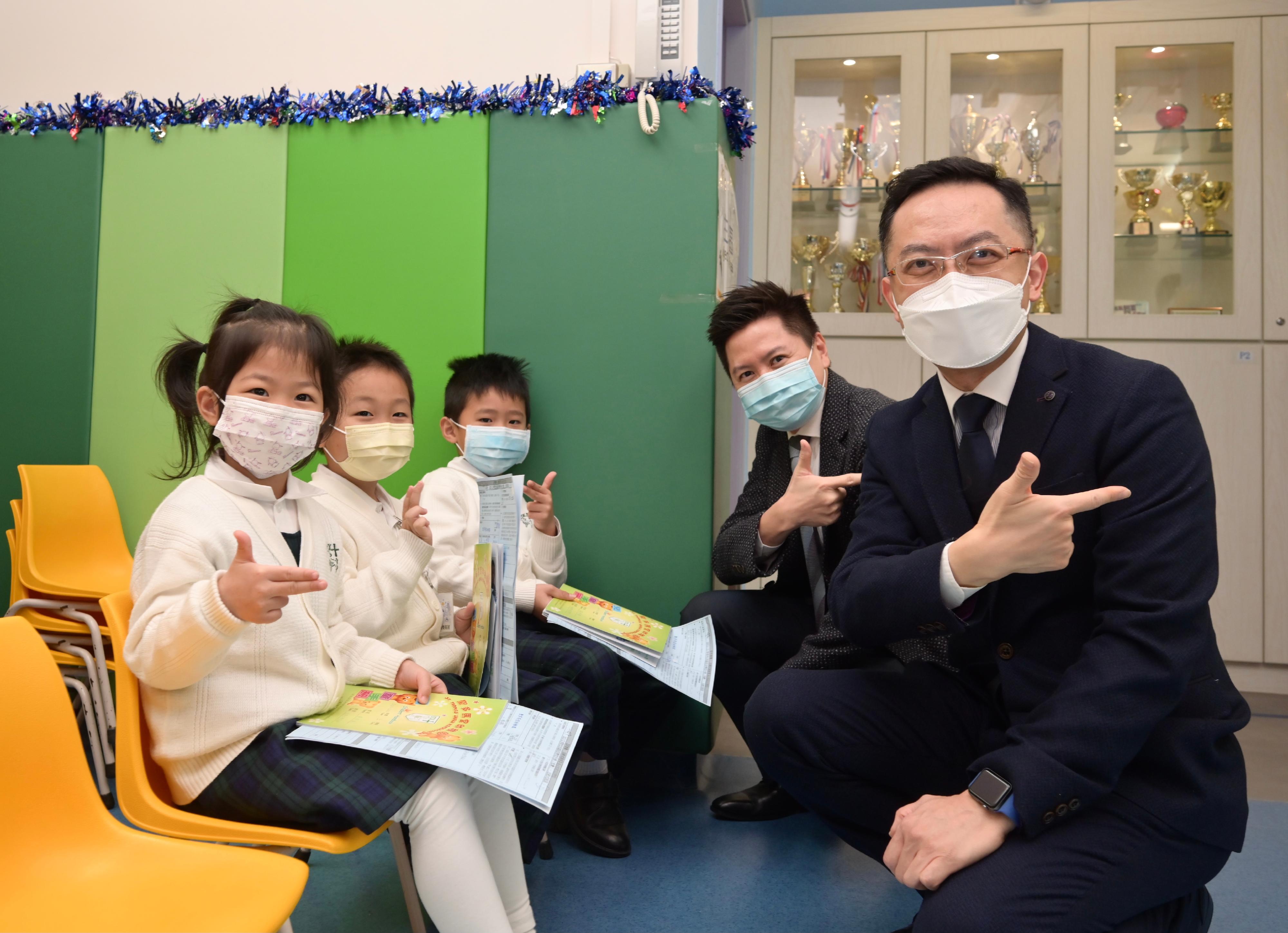 The Director of Health, Dr Ronald Lam, and the Controller of the Centre for Health Protection of the Department of Health, Dr Edwin Tsui, this morning (December 15) visited St Thomas' Church Kindergarten in Shek Kip Mei to view the implementation of the school outreach seasonal influenza vaccination service. Photo shows Dr Lam (first right) and Dr Tsui (second right) with pupils ready to receive vaccination.