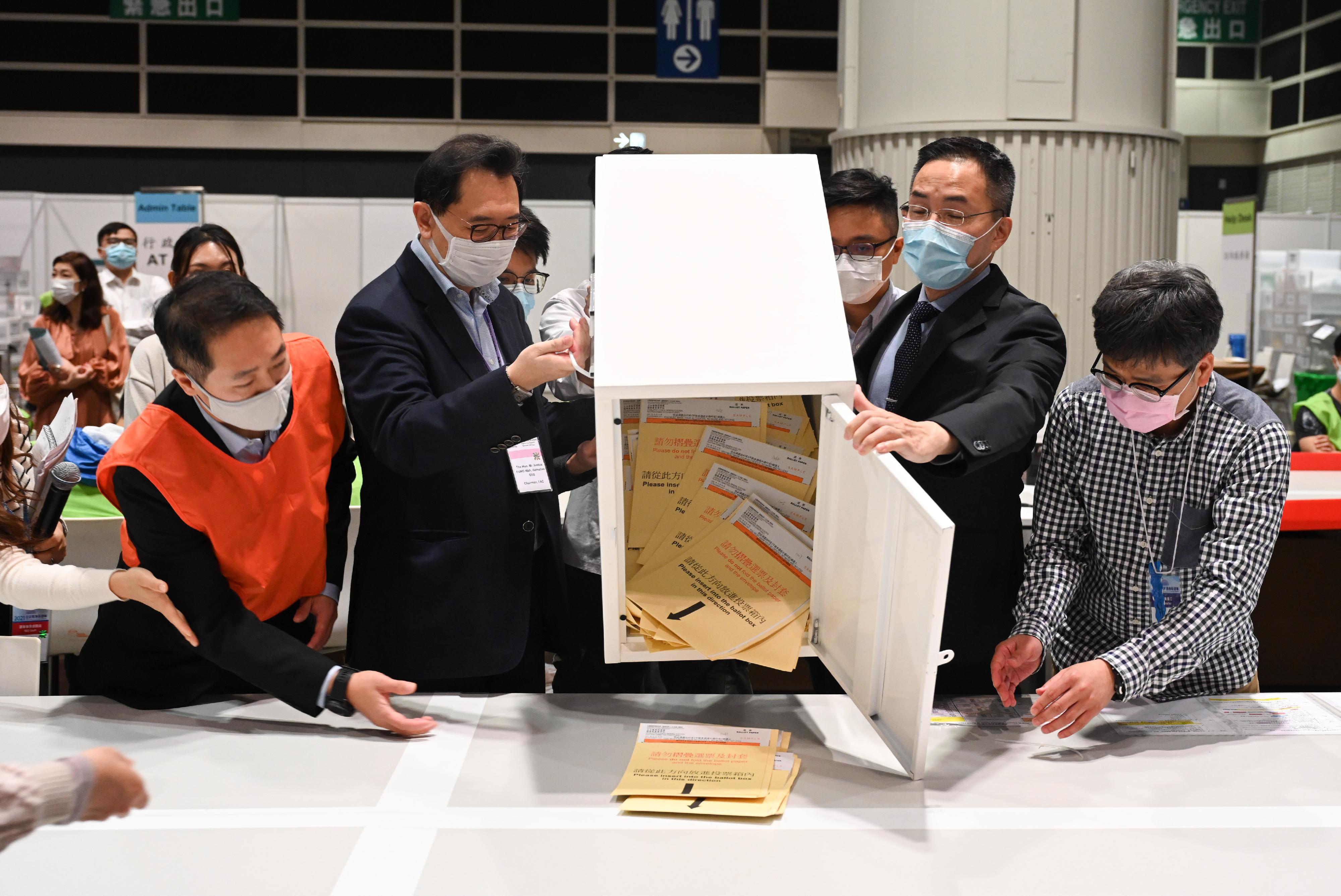 The Chairman of the Electoral Affairs Commission, Mr Justice Barnabas Fung Wah, visited the central counting station of the 2021 Legislative Council General Election at the Hong Kong Convention and Exhibition Centre and inspected the training sessions with practical sessions and simulated activities for counting staff. Photo shows Mr Justice Fung (second left), and the Permanent Secretary for Constitutional and Mainland Affairs, Mr Roy Tang (second right), in a simulation of emptying a ballot box.