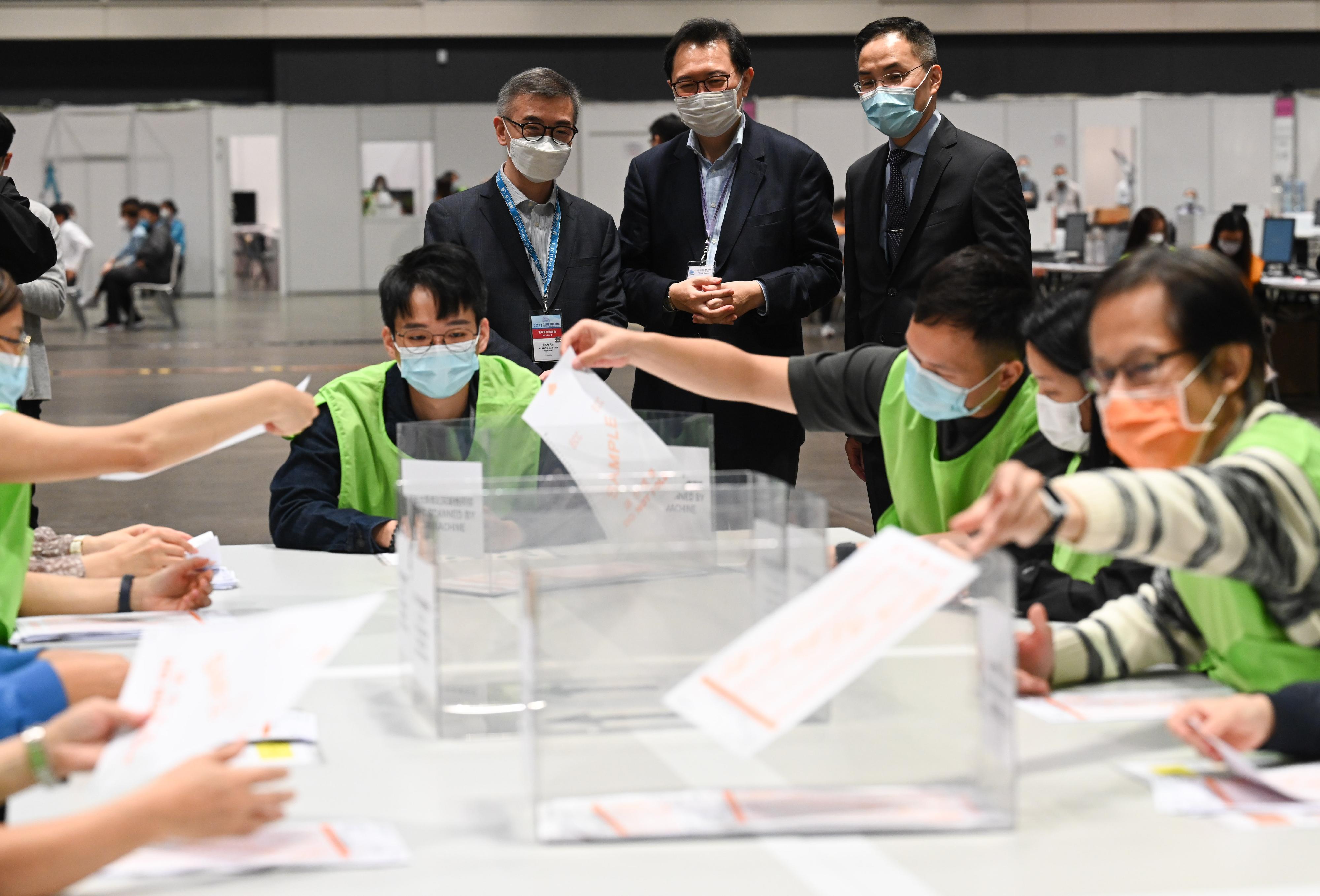 The Chairman of the Electoral Affairs Commission, Mr Justice Barnabas Fung Wah (back row, centre), visits the central counting station of the 2021 Legislative Council General Election at the Hong Kong Convention and Exhibition Centre and inspected the training sessions with practical sessions and simulated activities for counting staff. Also present are the Permanent Secretary for Constitutional and Mainland Affairs, Mr Roy Tang (back row, right), and the Senior Principal Executive Officer (Elections) of the Registration and Electoral Office, Mr Raymond Wang (back row, left).