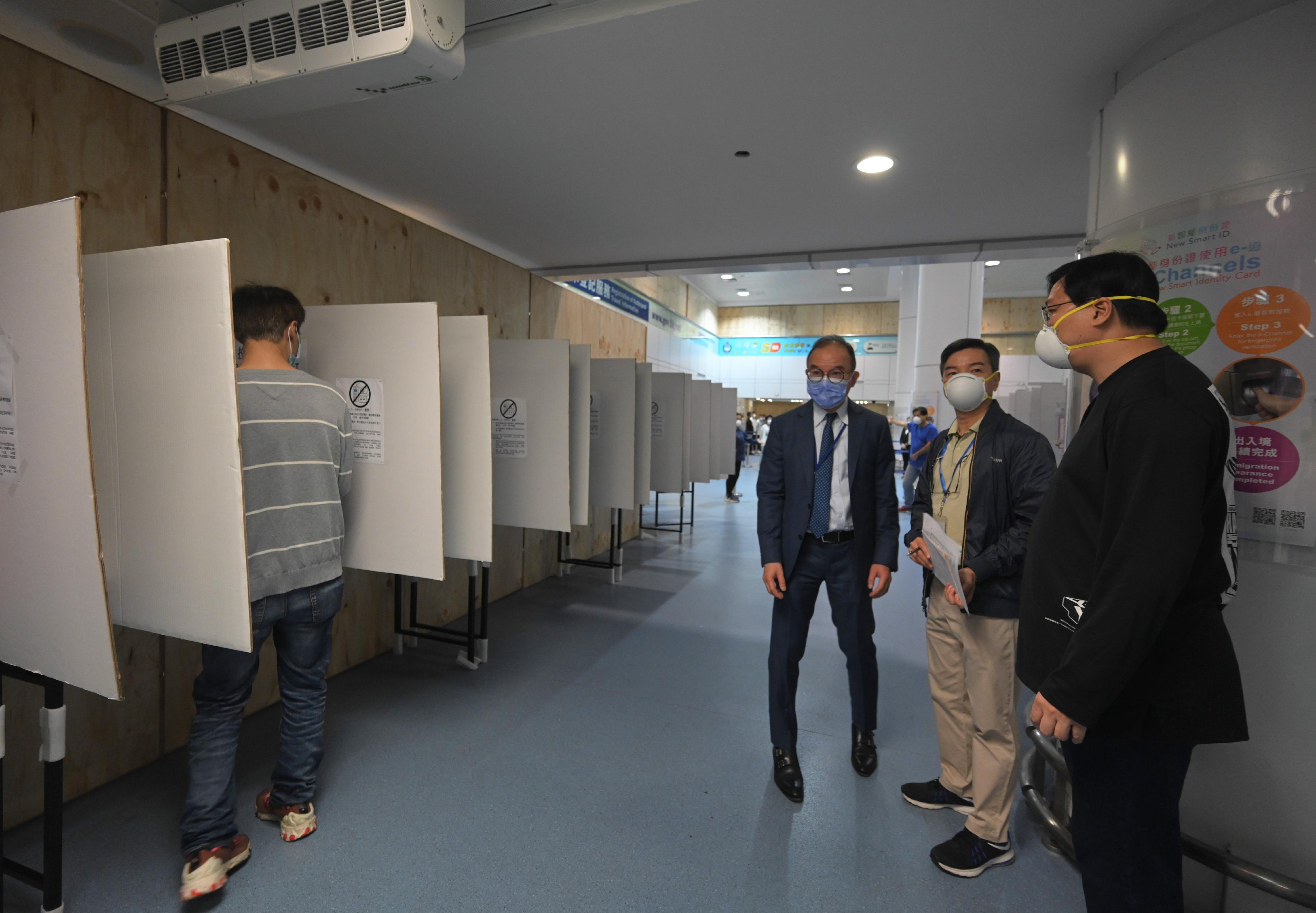 The Secretary for Constitutional and Mainland Affairs, Mr Erick Tsang Kwok-wai, today (December 16) inspected three boundary control point polling stations. Photo shows Mr Tsang (third right) observing the design of the voting compartments at the polling station located at Lo Wu boundary control point.