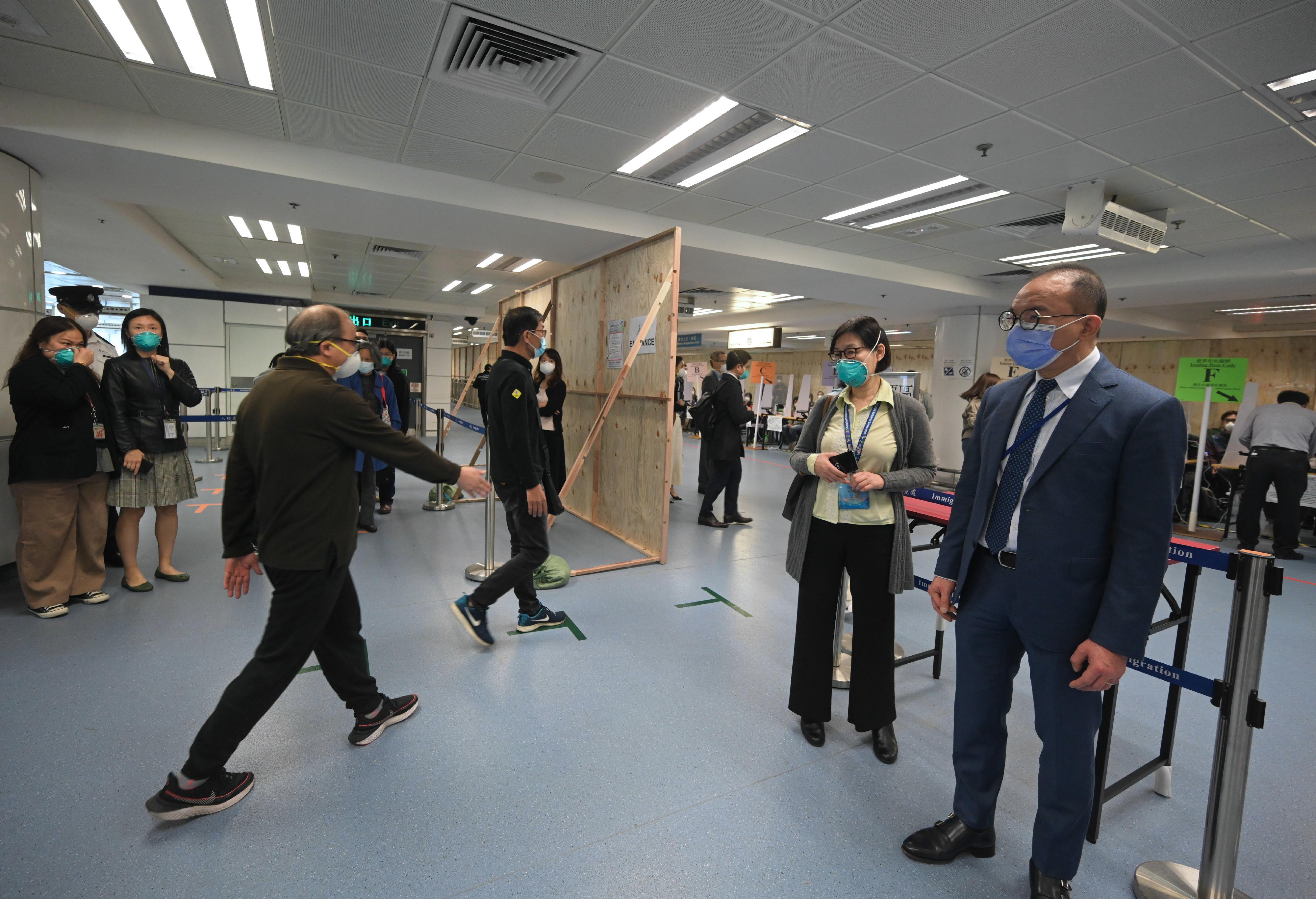 The Secretary for Constitutional and Mainland Affairs, Mr Erick Tsang Kwok-wai, today (December 16) inspected three boundary control point polling stations. Photo shows Mr Tsang (right) observing the training and practice sessions with simulated scenarios for electoral staff at the polling station located at Lo Wu boundary control point.