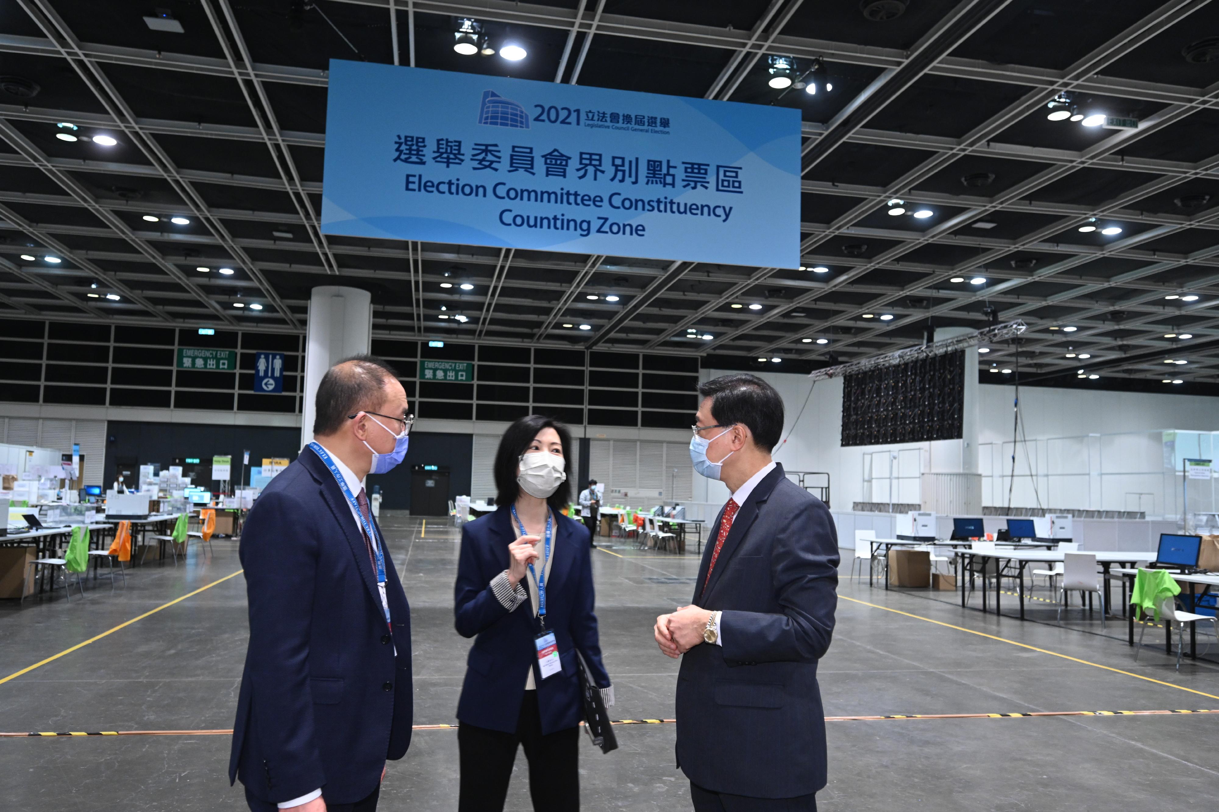 The Chief Secretary for Administration, Mr John Lee, visited the Hong Kong Convention and Exhibition Centre today (December 17) to inspect the preparatory work progress of the central counting station for the Legislative Council General Election. Photo shows Mr Lee (first right) and the Secretary for Constitutional and Mainland Affairs, Mr Erick Tsang Kwok-wai (first left), chatting with a staff member to learn about the preparation work of the Election Committee Constituency Counting Zone.