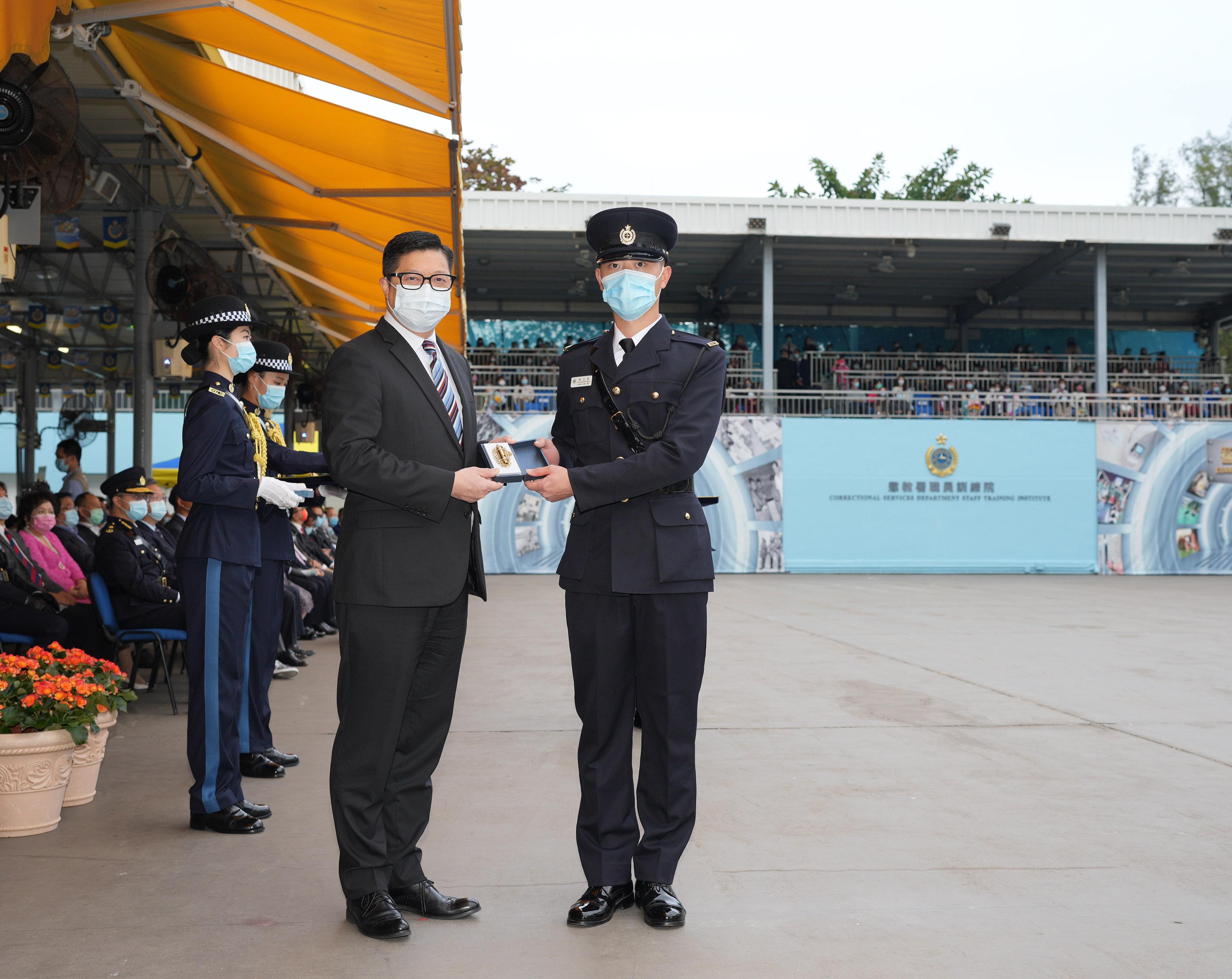 The Correctional Services Department held a passing-out parade at the Staff Training Institute in Stanley today (December 17).  Photo shows the Secretary for Security, Mr Tang Ping-keung (left), presenting a Best Recruit Award, the Golden Whistle, to Assistant Officer II Mr Chen Chi-ho.