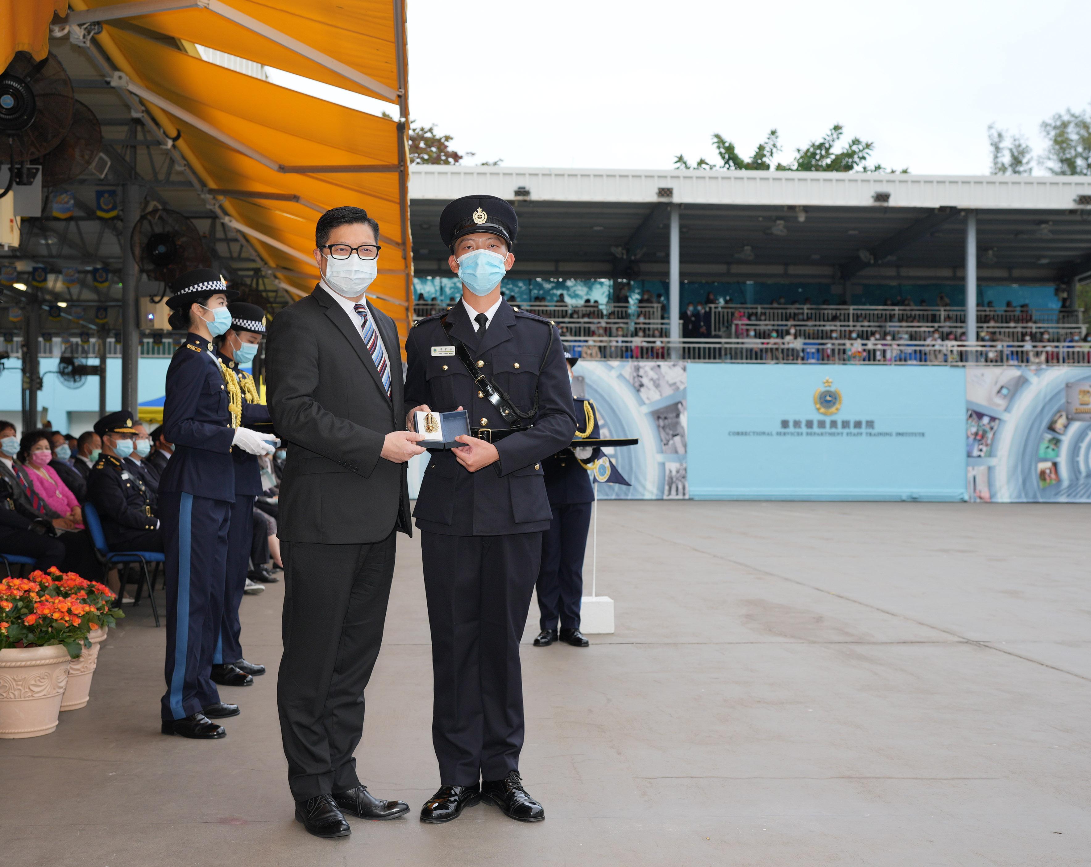 The Correctional Services Department held a passing-out parade at the Staff Training Institute in Stanley today (December 17).  Photo shows the Secretary for Security, Mr Tang Ping-keung (left), presenting a Best Recruit Award, the Golden Whistle, to Assistant Officer II Mr Li Tung-wun.