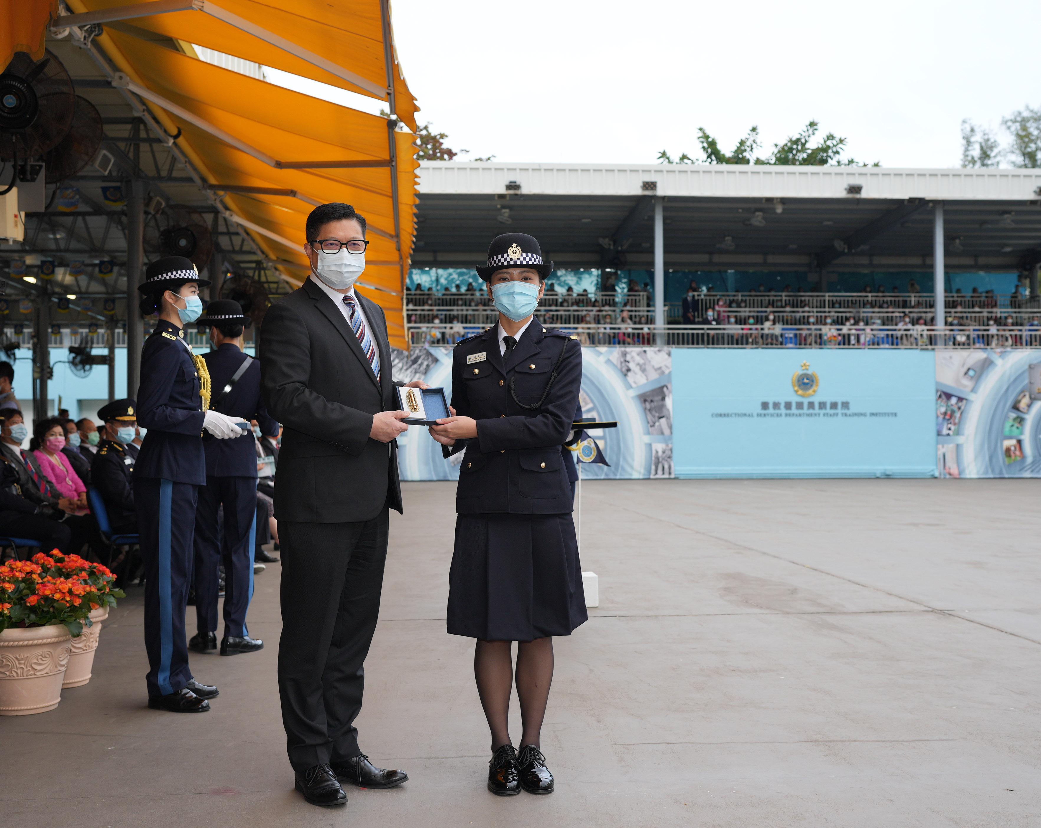 The Correctional Services Department held a passing-out parade at the Staff Training Institute in Stanley today (December 17).  Photo shows the Secretary for Security, Mr Tang Ping-keung (left), presenting a Best Recruit Award, the Golden Whistle, to Assistant Officer II Ms Amanda Cheung.