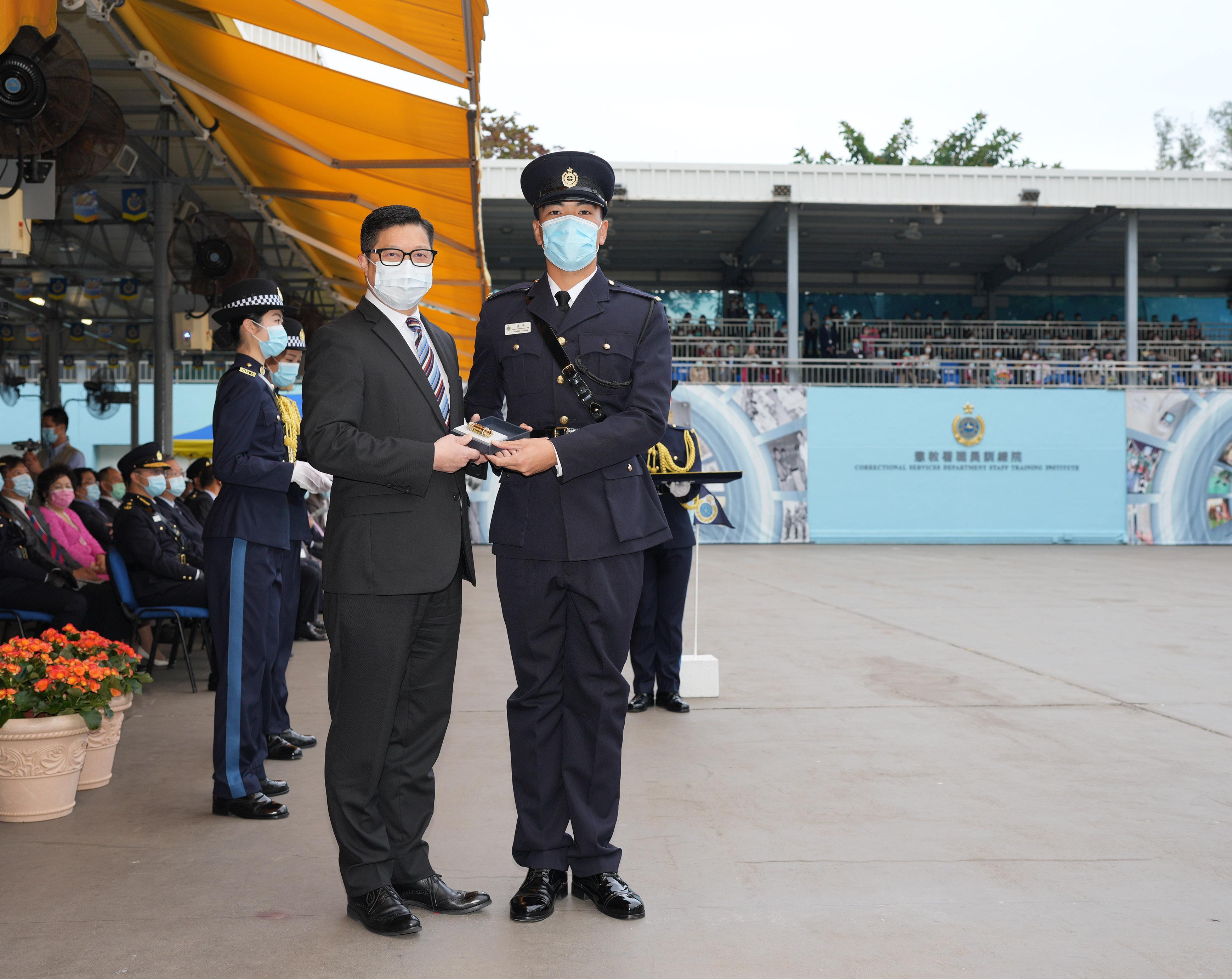 The Correctional Services Department held a passing-out parade at the Staff Training Institute in Stanley today (December 17).  Photo shows the Secretary for Security, Mr Tang Ping-keung (left), presenting a Best Recruit Award, the Golden Whistle, to Assistant Officer II Mr Yeung Yeung.