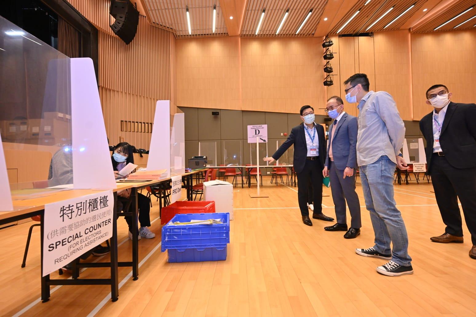 The Secretary for Constitutional and Mainland Affairs, Mr Erick Tsang Kwok-wai, today (December 18) visited various polling stations to inspect the preparatory work and rehearsal sessions for the Legislative Council General Election. Photo shows Mr Tsang (third right) being briefed on the operation of special counter by electoral staff at the polling station located at North Point Community Hall.