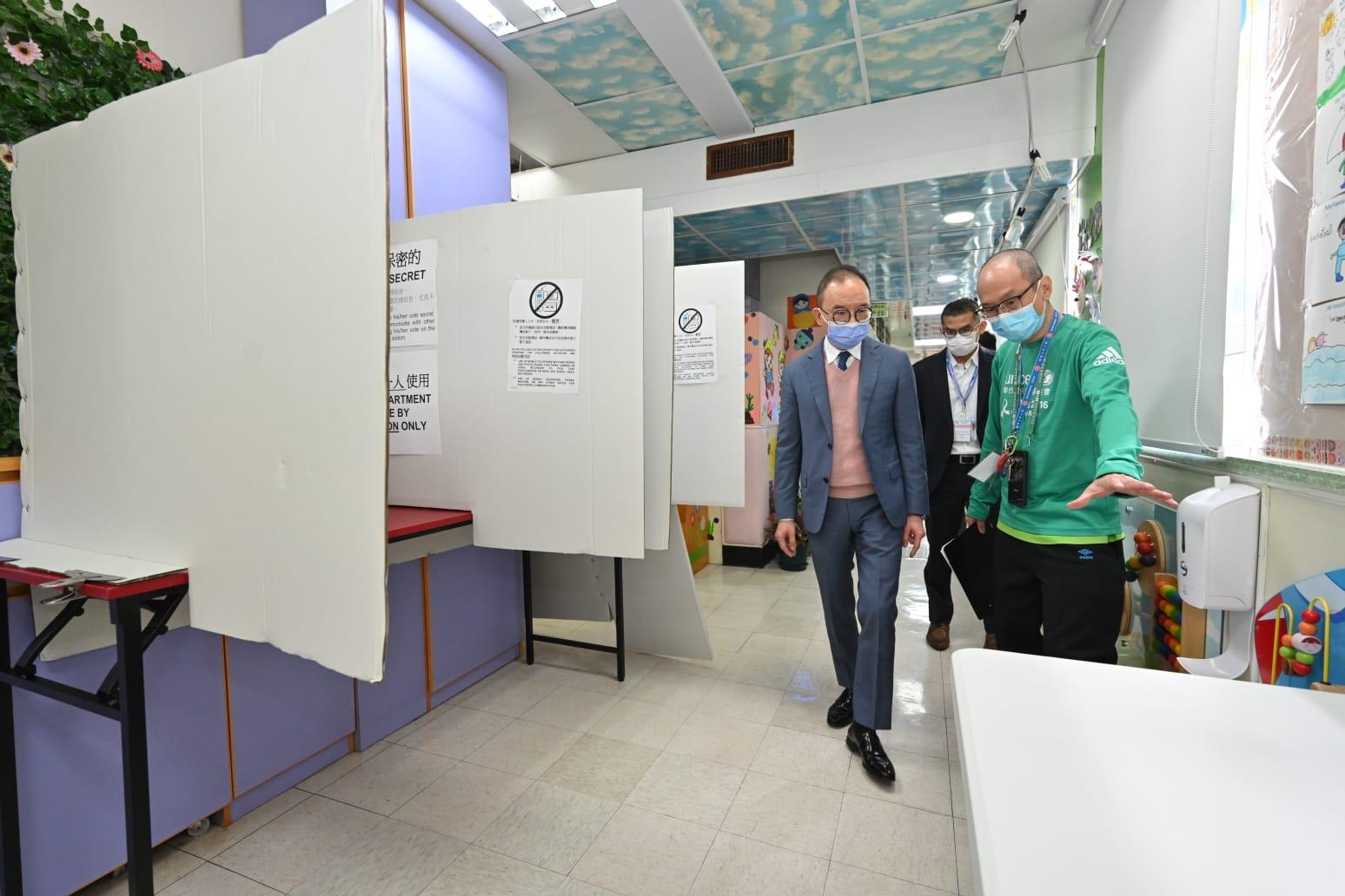 The Secretary for Constitutional and Mainland Affairs, Mr Erick Tsang Kwok-wai, today (December 18) visited various polling stations to inspect the preparatory work and rehearsal sessions for the Legislative Council General Election. Photo shows Mr Tsang (left) being briefed on the design of the voting compartments by electoral staff at the polling station at St Anna Anglo-Chinese Kindergarten in Quarry Bay.