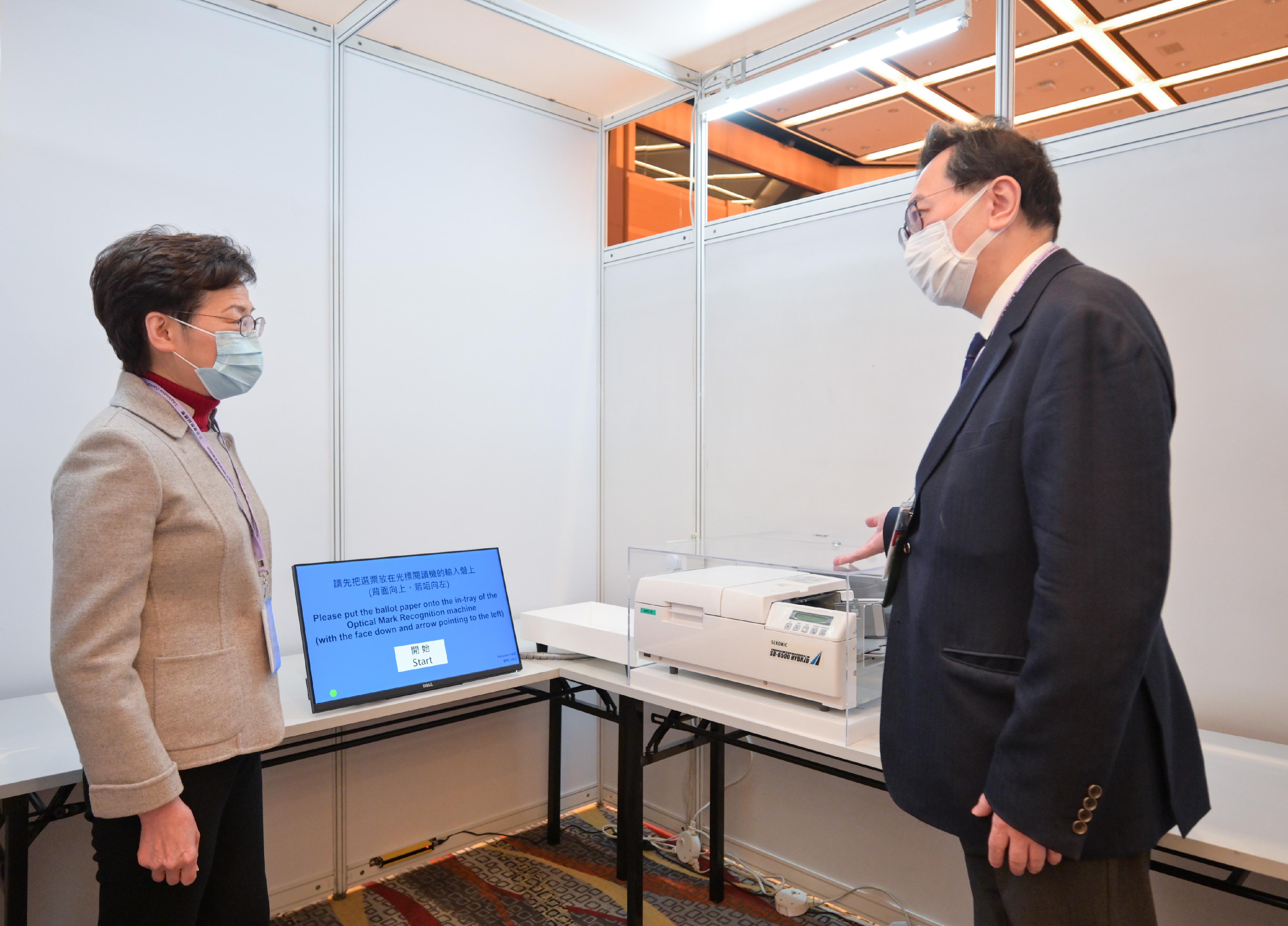 The Chief Executive, Mrs Carrie Lam, visited the Election Committee constituency polling station of the 2021 Legislative Council General Election at the Hong Kong Convention and Exhibition Centre this morning (December 19). Photo shows Mrs Lam (left) being briefed by the Chairman of the Electoral Affairs Commission, Mr Justice Barnabas Fung Wah (right), on polling arrangements.