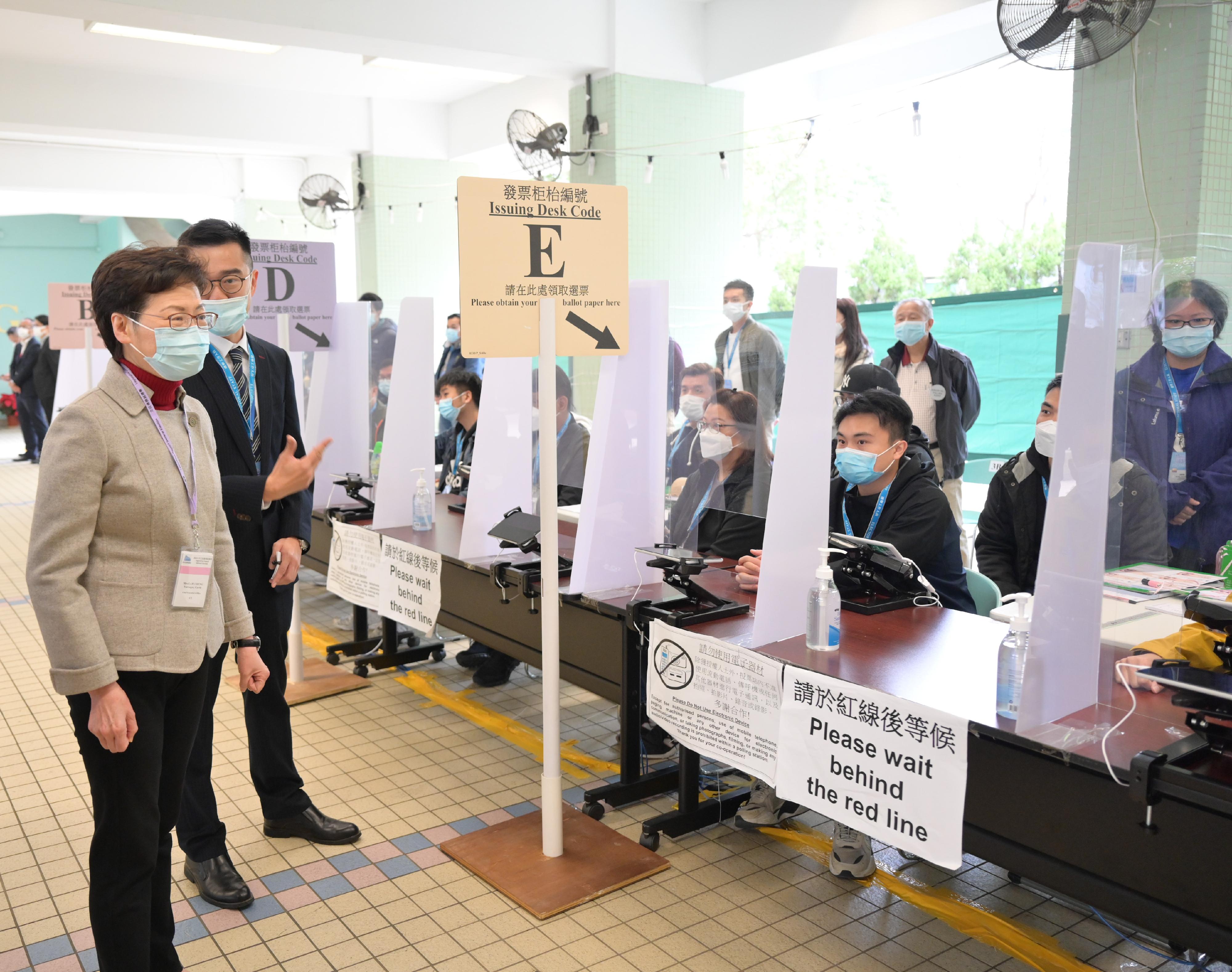 The Chief Executive, Mrs Carrie Lam, visited a polling station at Yan Chai Hospital Law Chan Chor Si College for the 2021 Legislative Council General Election this morning (December 19). Photo shows Mrs Lam (first left) being briefed on the operation of the polling station.