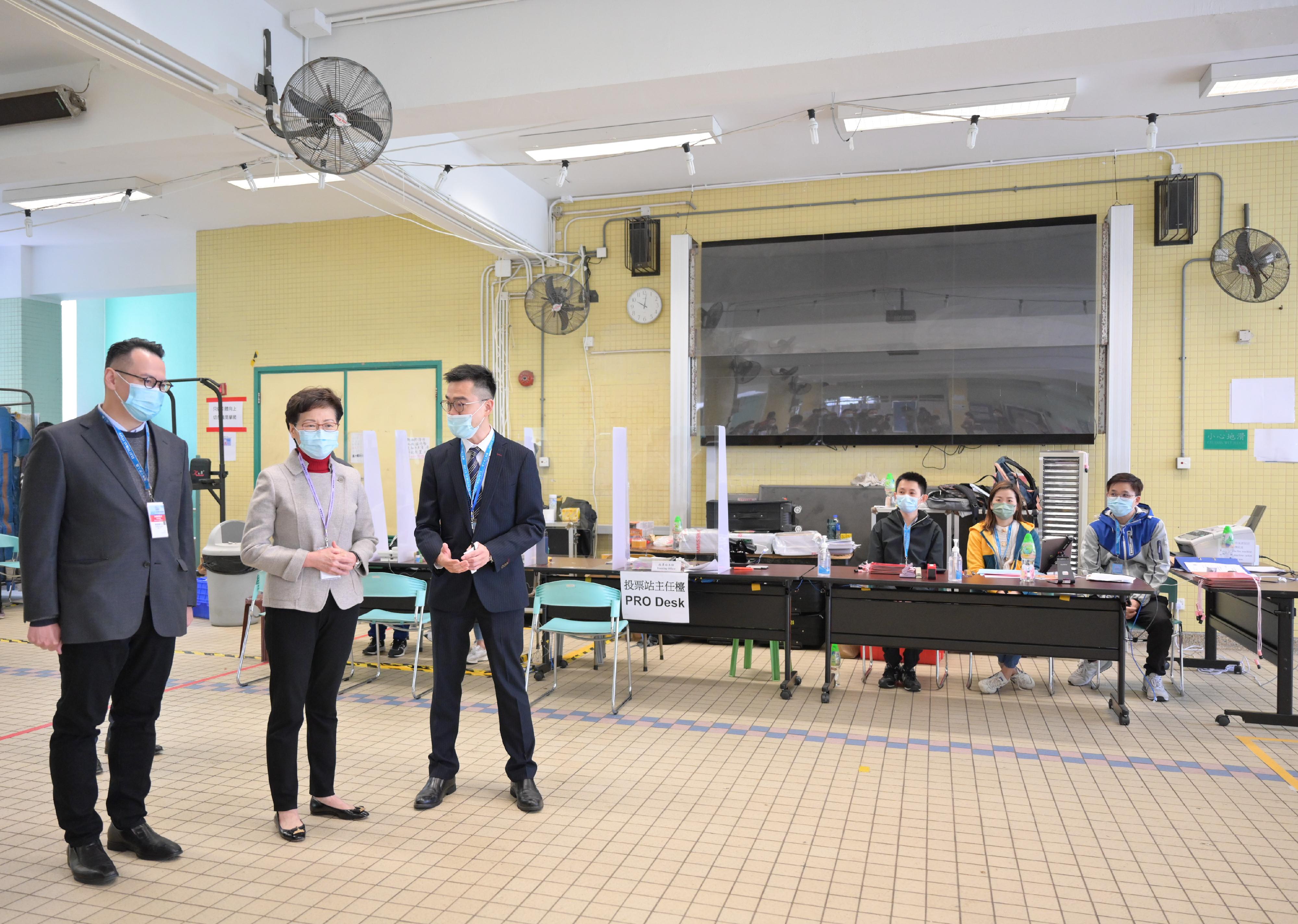 The Chief Executive, Mrs Carrie Lam, visited a polling station at Yan Chai Hospital Law Chan Chor Si College for the 2021 Legislative Council General Election this morning (December 19). Photo shows Mrs Lam (second left) being briefed on the operation of the polling station.