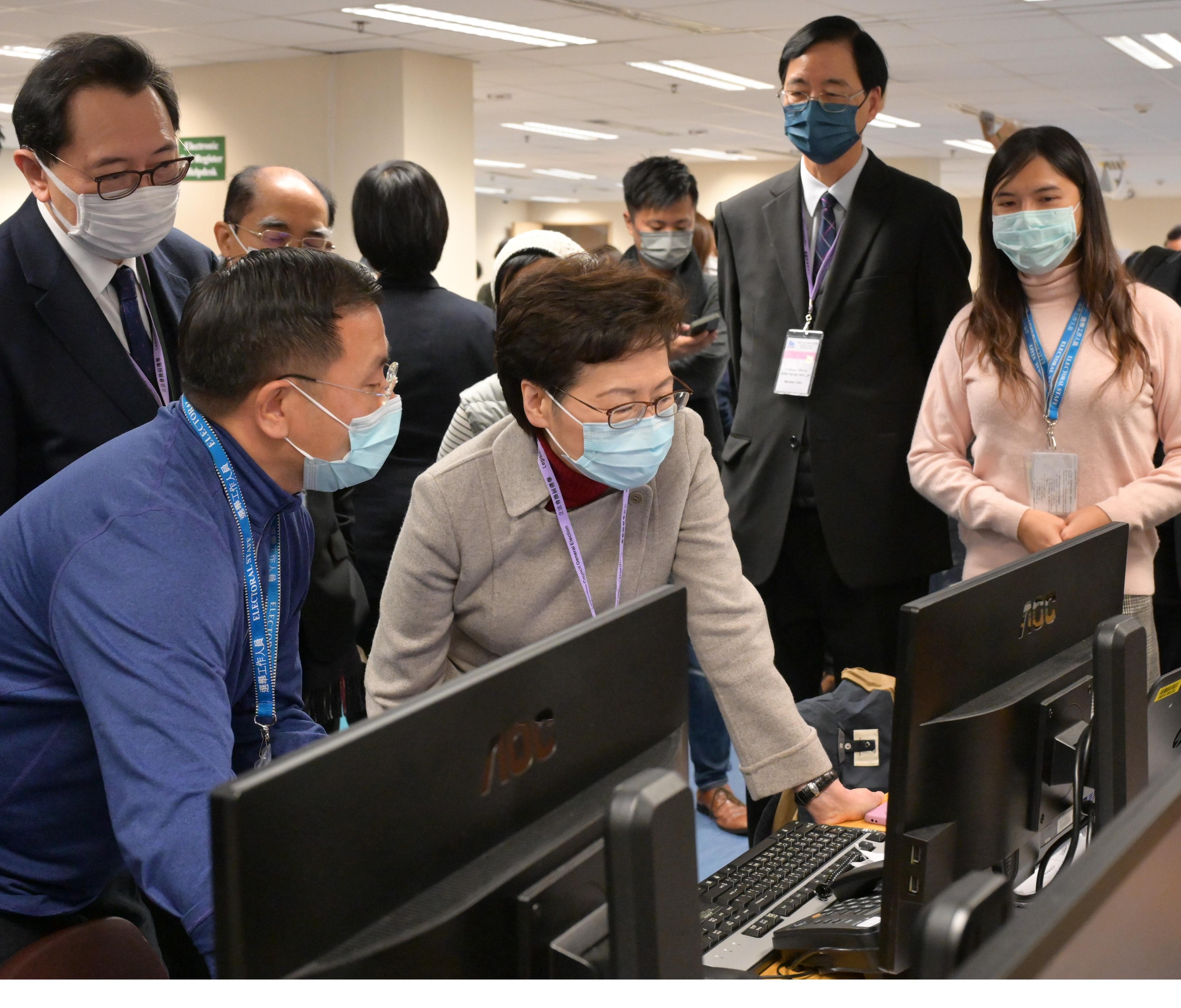 The Chief Executive, Mrs Carrie Lam (front row, second left), accompanied by the Chairman of the Electoral Affairs Commission, Mr Justice Barnabas Fung Wah (back row, first left), visits the Central Command Centre of the 2021 Legislative Council General Election this morning (December 19) to inspect its operation.
