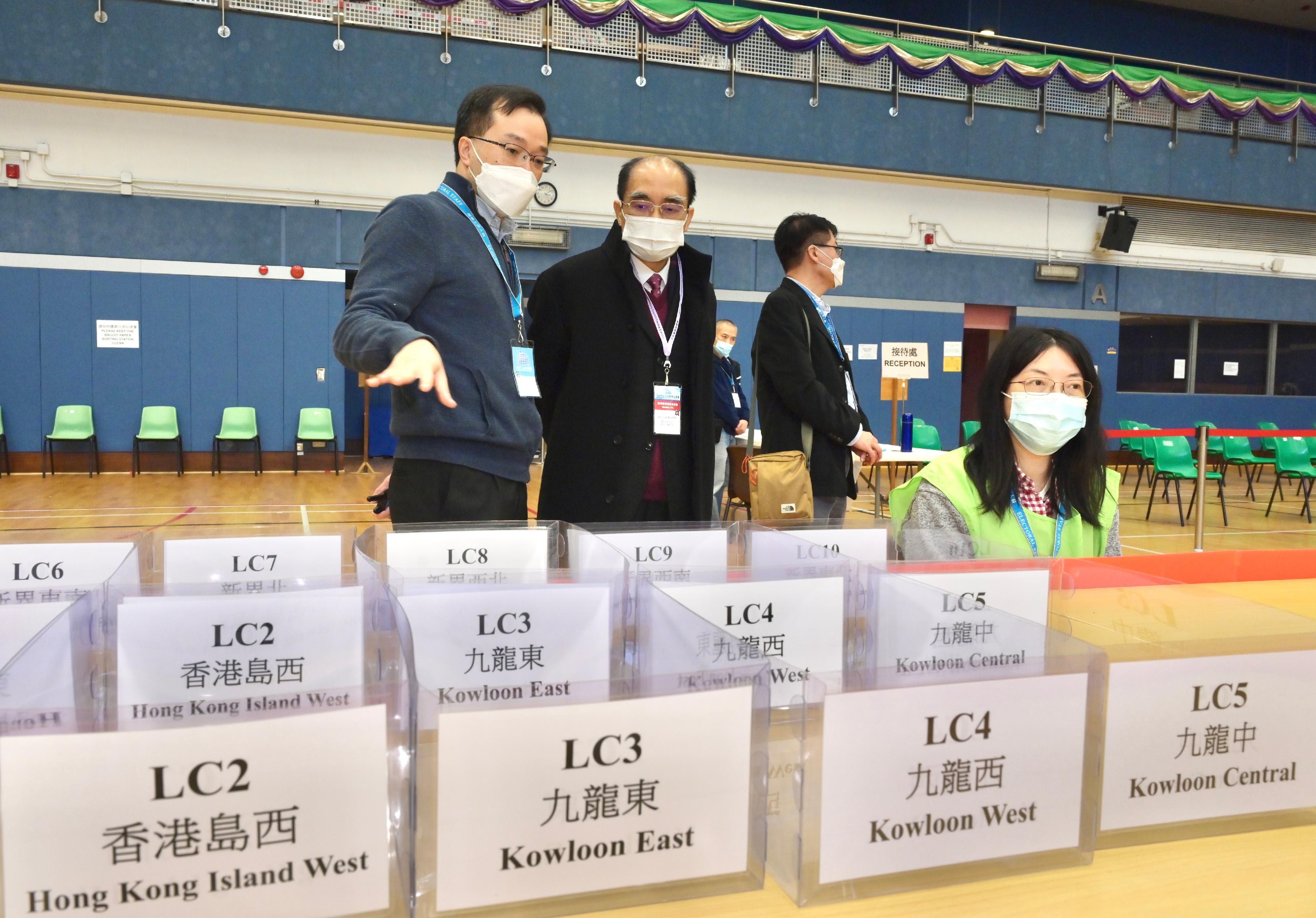Electoral Affairs Commission member Mr Arthur Luk, SC (second left), today (December 19) visits the ballot paper sorting station of the 2021 Legislative Council General Election at Shun Lee Tsuen Sports Centre.