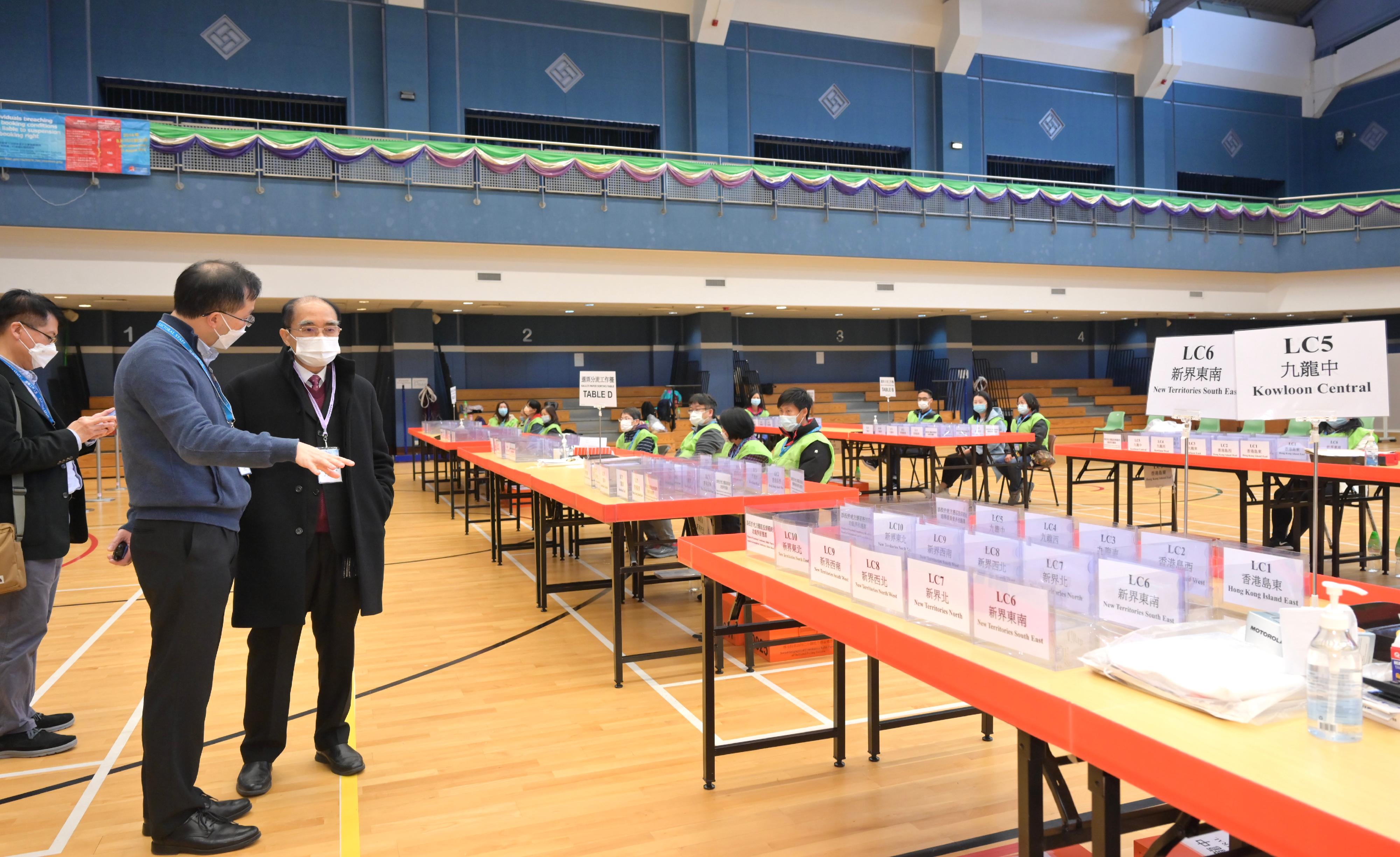 Electoral Affairs Commission member Mr Arthur Luk, SC (right), today (December 19) visits the ballot paper sorting station of the 2021 Legislative Council General Election at Shun Lee Tsuen Sports Centre.