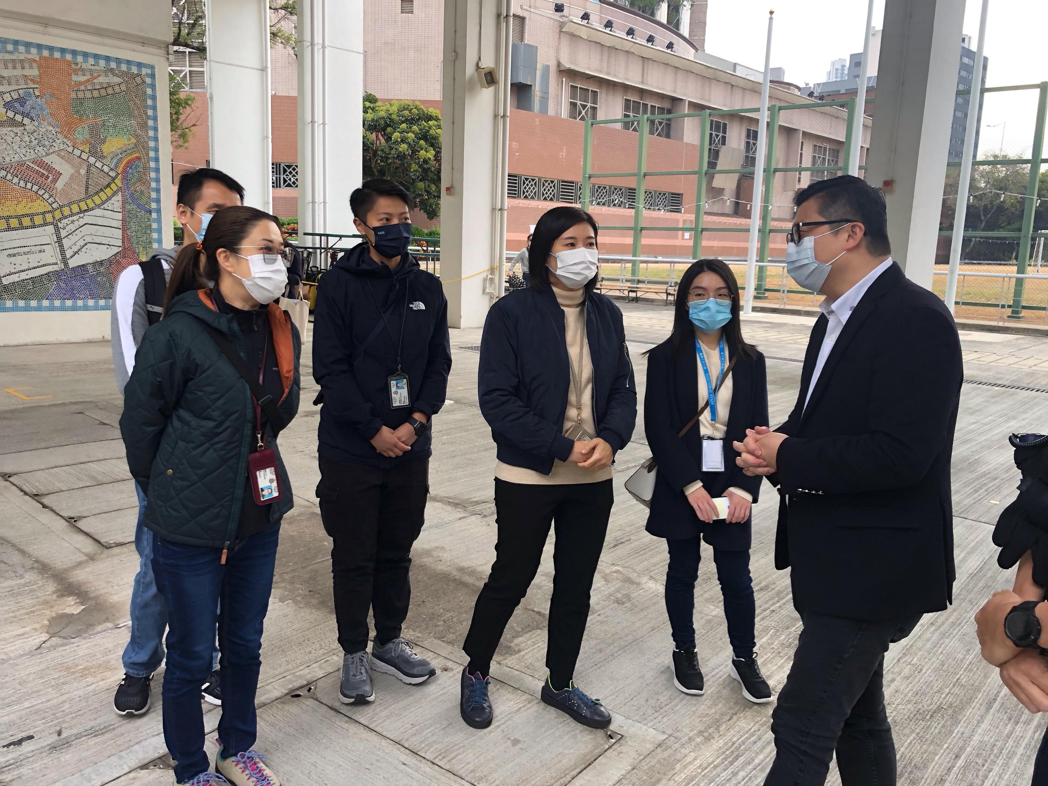 The 2021 Legislative Council General Election is held today (December 19). The Secretary for Security, Mr Tang Ping-keung, visited polling stations in various districts and the Emergency Monitoring and Support Centre of the Security Bureau activated for the election soon after he voted this morning to ensure safe and orderly conduct of the election. Photo shows Mr Tang (first right) having a conversation with the personnel on duty at a polling station in Mong Kok and giving them words of encouragement.