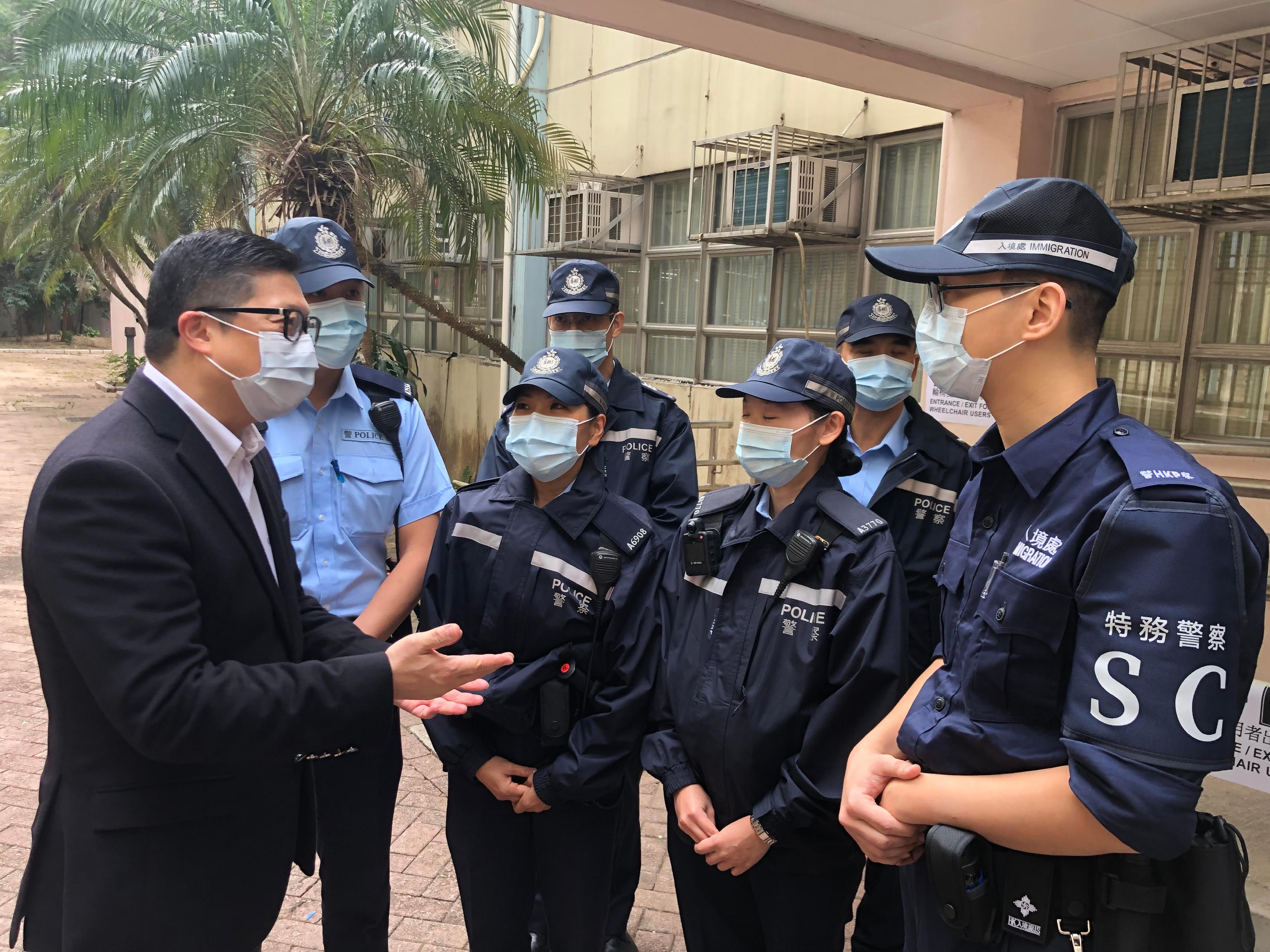The 2021 Legislative Council General Election is held today (December 19). The Secretary for Security, Mr Tang Ping-keung, visited polling stations in various districts and the Emergency Monitoring and Support Centre of the Security Bureau activated for the election soon after he voted this morning to ensure safe and orderly conduct of the election. Photo shows Mr Tang (first left) having a conversation with the Special Constables stationed at a polling station in Wong Tai Sin and giving them words of encouragement.