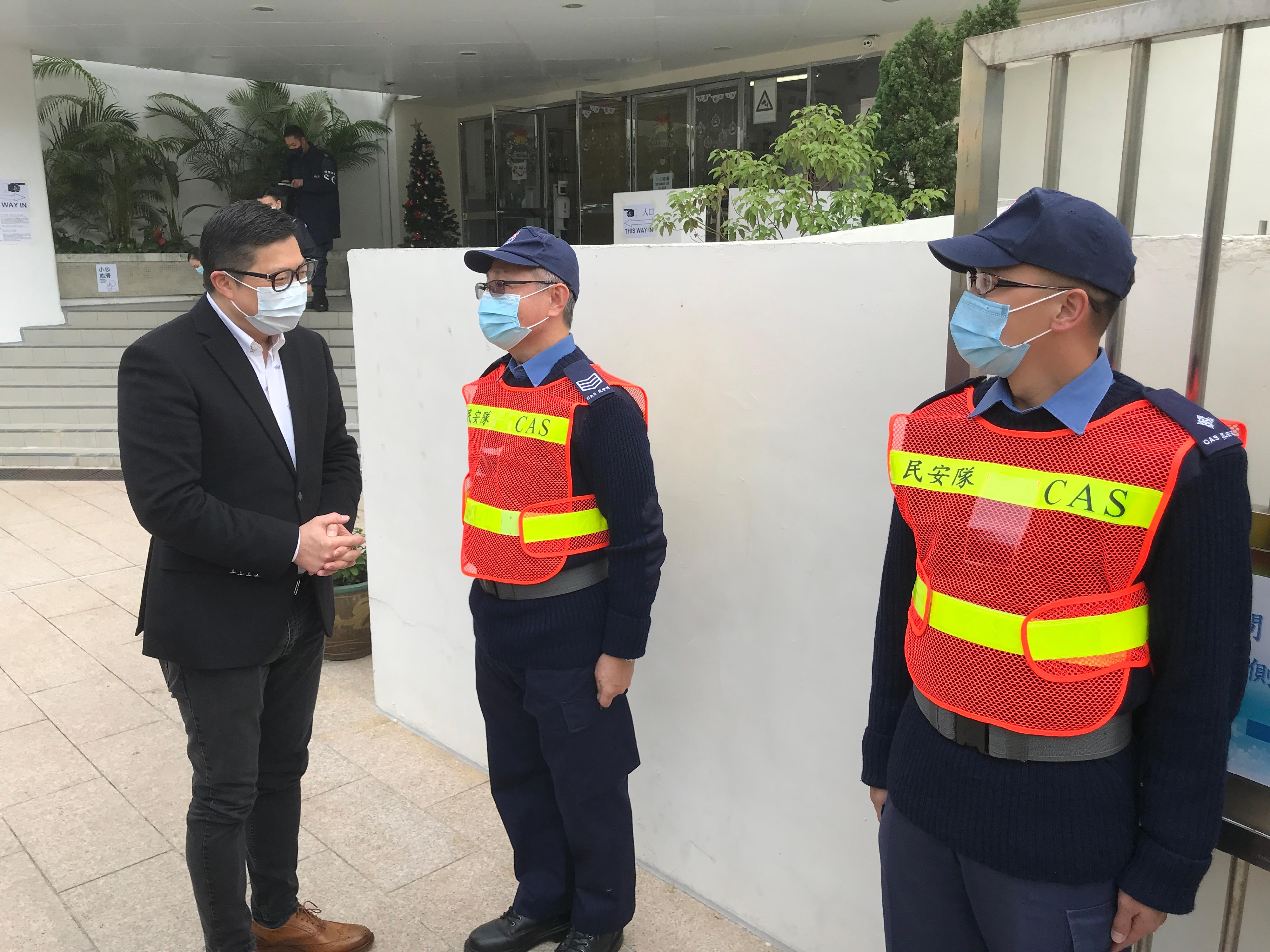 The 2021 Legislative Council General Election is held today (December 19). The Secretary for Security, Mr Tang Ping-keung, visited polling stations in various districts and the Emergency Monitoring and Support Centre of the Security Bureau activated for the election soon after he voted this morning to ensure safe and orderly conduct of the election. Photo shows Mr Tang (first left) having a conversation with Civil Aid Service's personnel on duty at a polling station in Kwai Chung and giving them words of encouragement.

