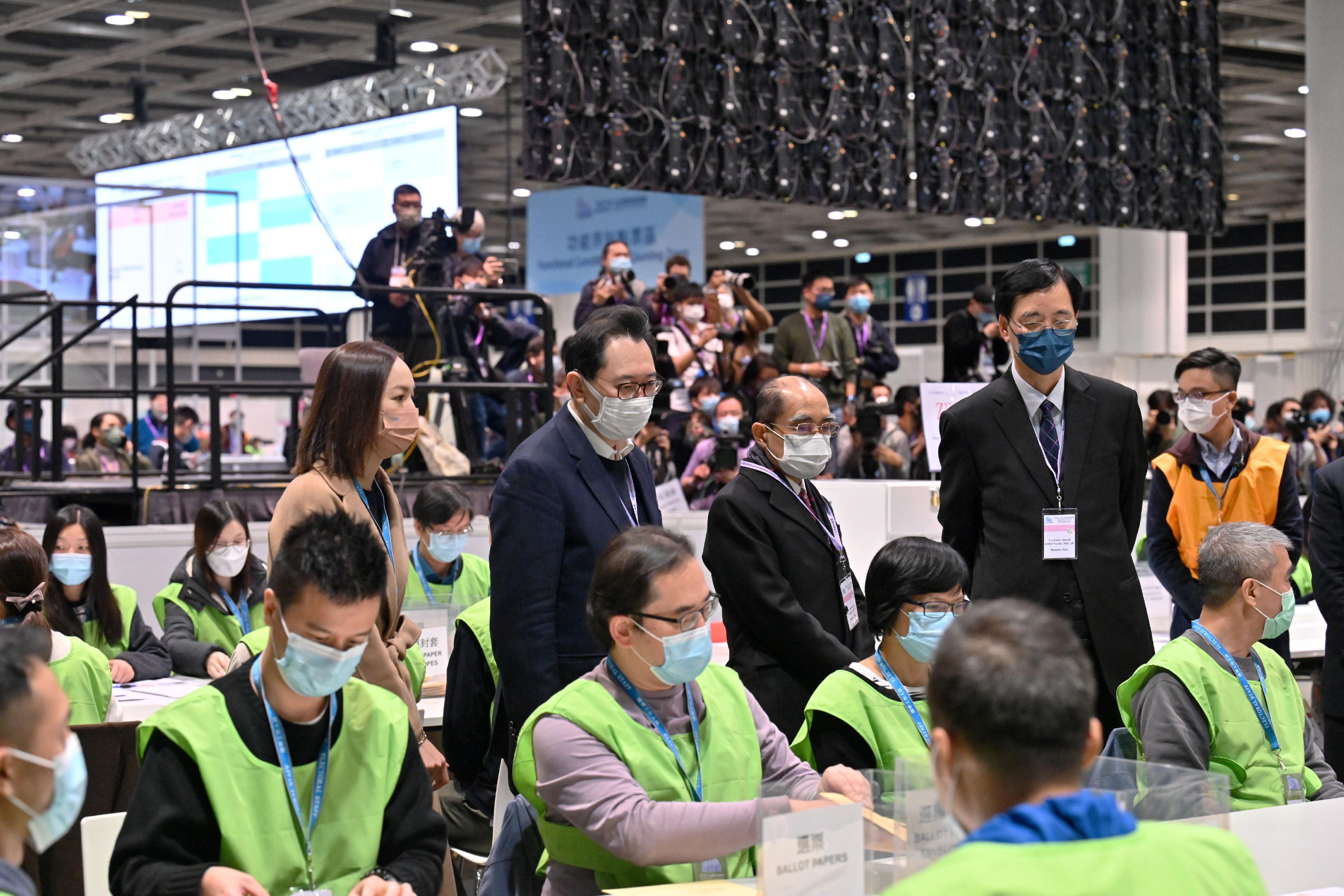 The Chairman of the Electoral Affairs Commission (EAC), Mr Justice Barnabas Fung Wah (second left), EAC members Mr Arthur Luk, SC (second right) and Professor Daniel Shek (first right) inspected the counting process at the central counting station at the Hong Kong Convention and Exhibition Centre for the 2021 Legislative Council General Election last night (December 19).
