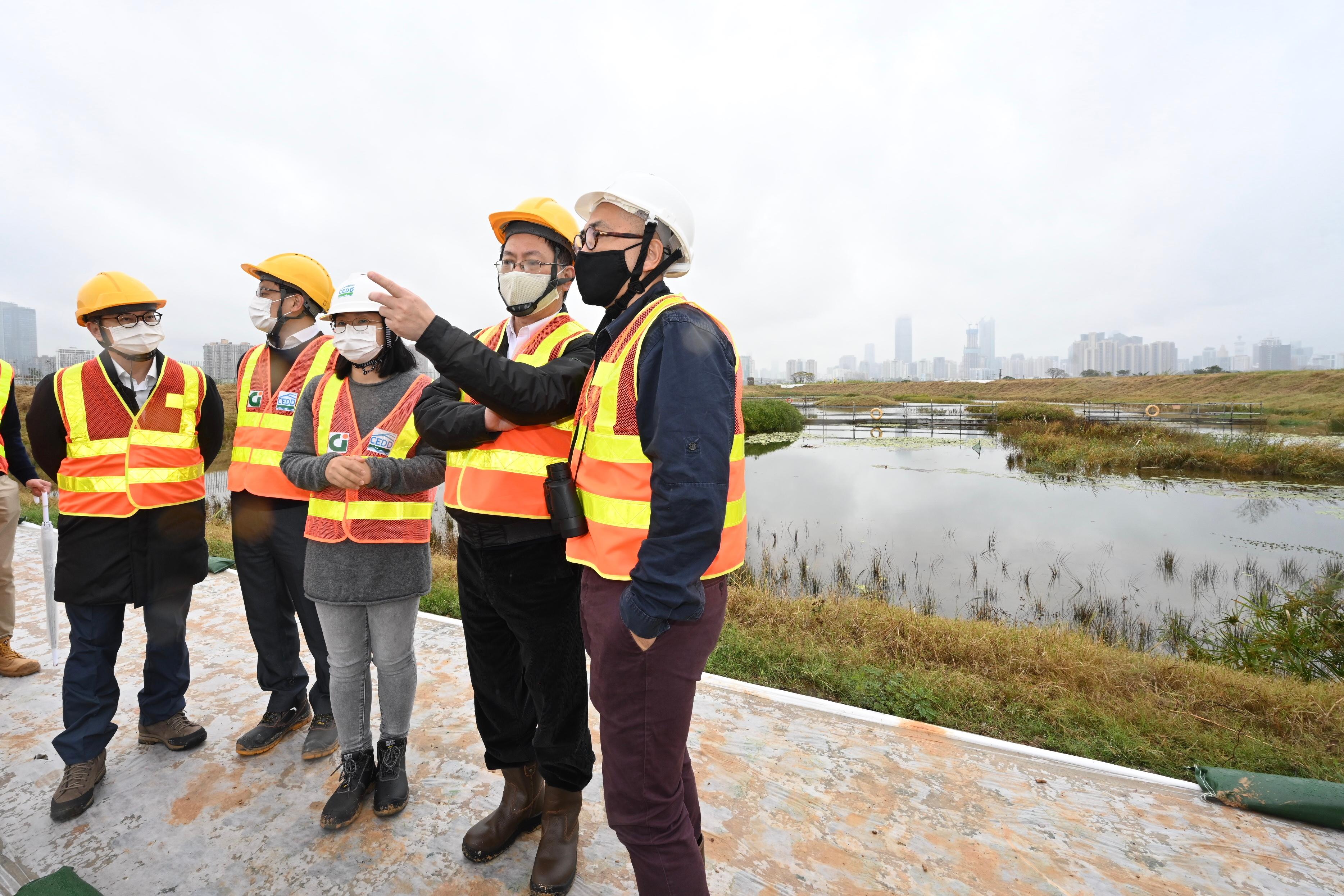 The Secretary for Innovation and Technology, Mr Alfred Sit (second right), today (December 21) better understands the ecological conservation work of the Lok Ma Chau Loop during his visit to the Loop construction site. Looking on is the Under Secretary for Innovation and Technology, Dr David Chung (first left).