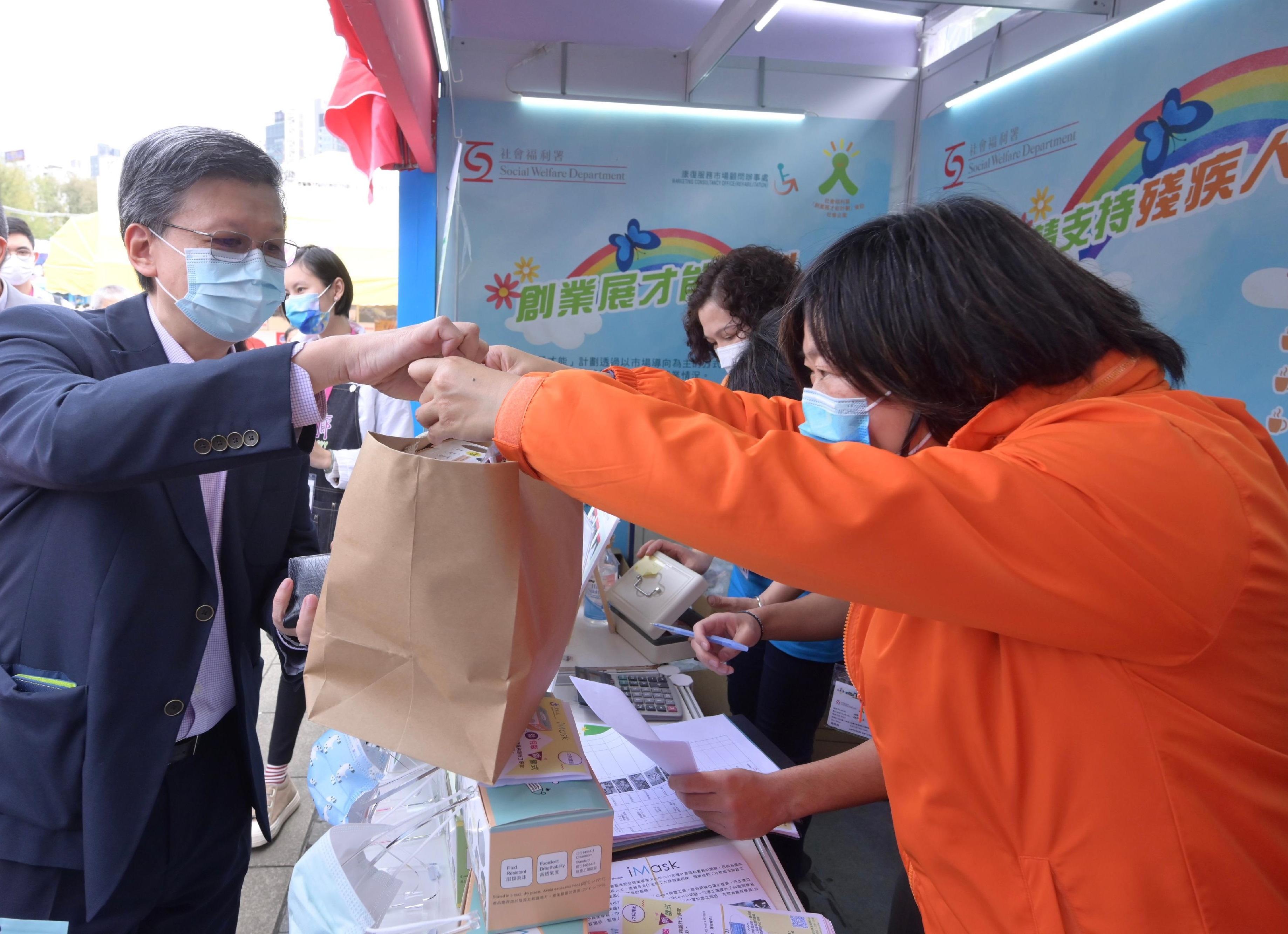 The Director of Social Welfare, Mr Gordon Leung, and the Chairperson of the Advisory Committee on Enhancing Employment of People with Disabilities, Dr Kevin Lau, visited the 55th Hong Kong Brands and Products Expo at Victoria Park today (December 22). Photo shows Mr Leung (first left) shopping at a booth set up by a rehabilitation service unit.
