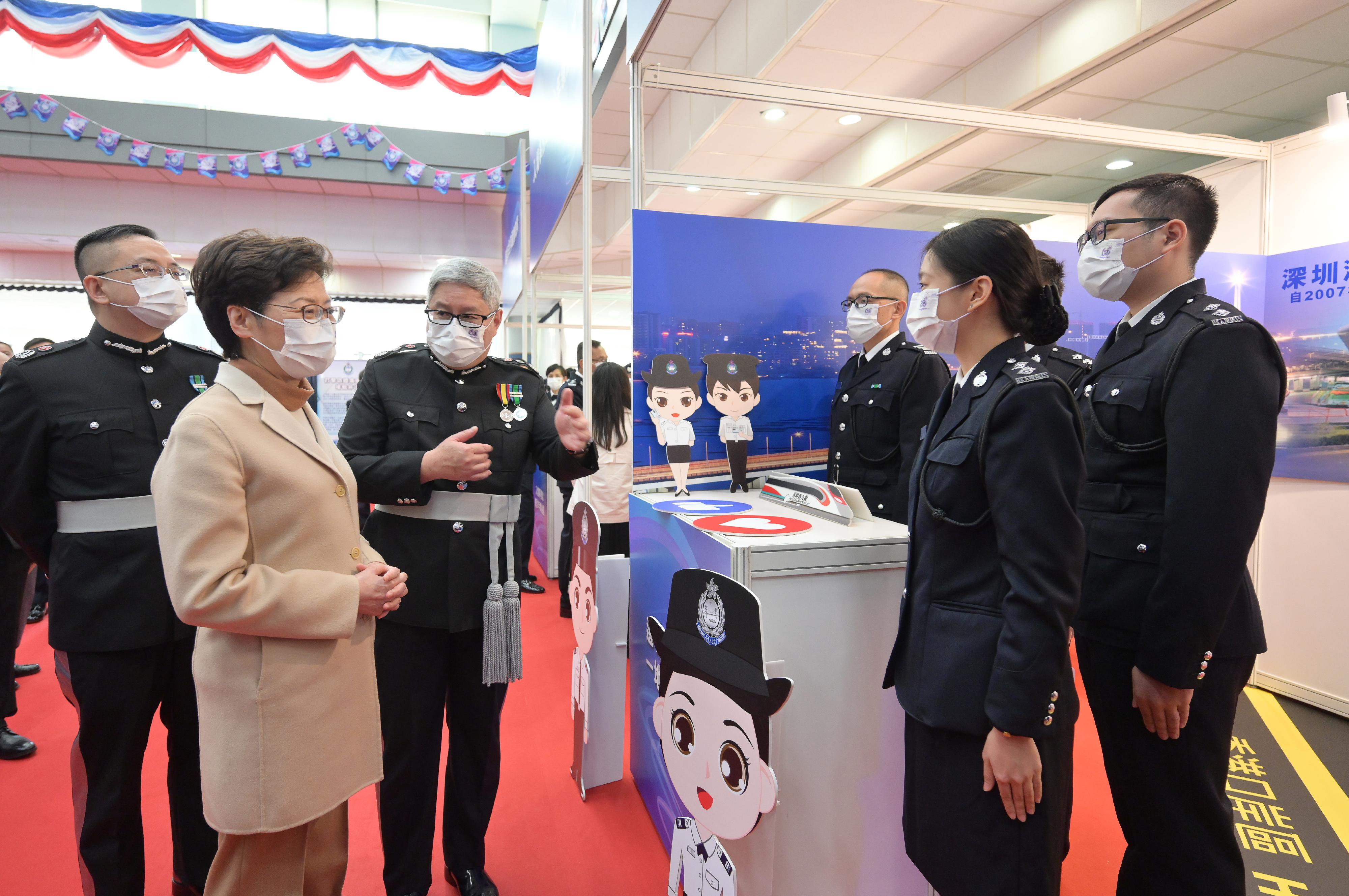 The Chief Executive, Mrs Carrie Lam (second left), visits a booth introducing the work of the Immigration Department after the Immigration Department Passing-out Parade cum 60th Anniversary Grand Parade today (December 30).