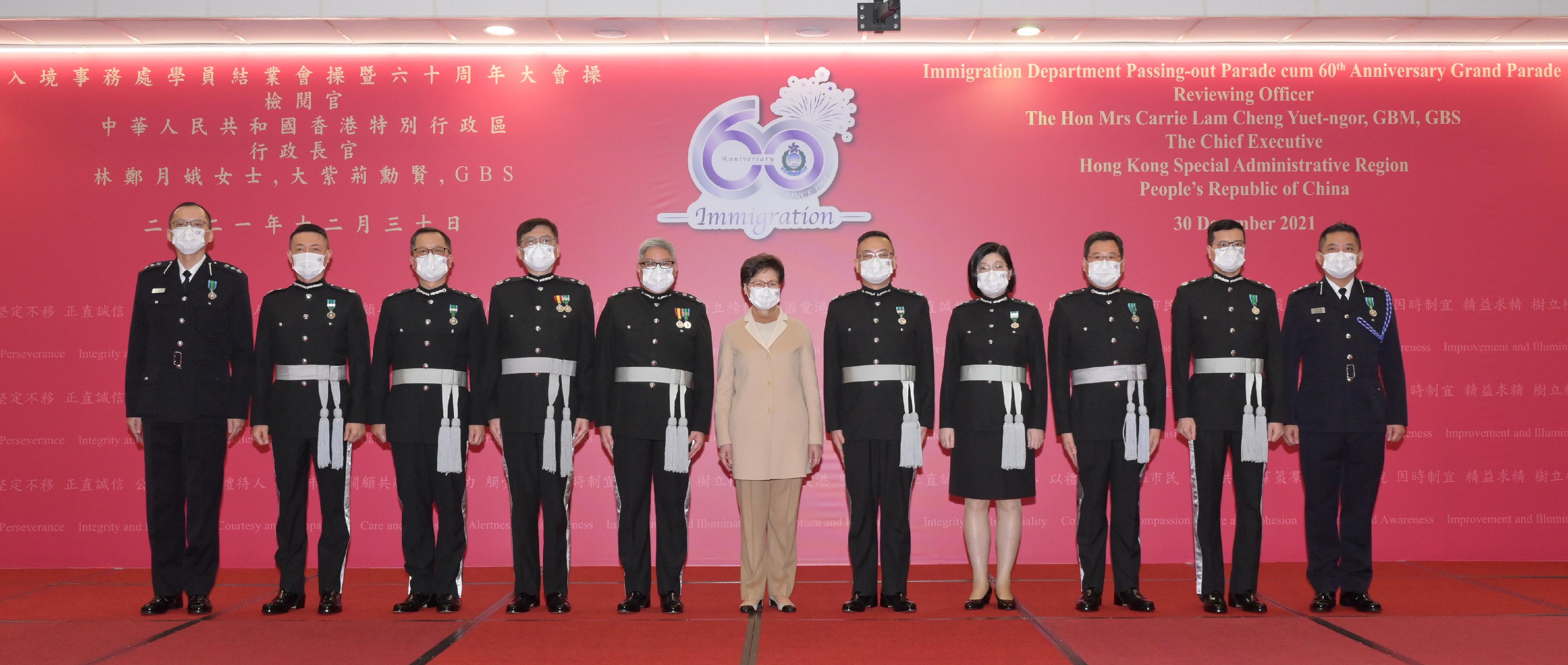 The Immigration Department Passing-out Parade cum 60th Anniversary Grand Parade was held today (December 30). Photo shows the Chief Executive, Mrs Carrie Lam (sixth right), taking a photo with the directorate grade officers of the Immigration Department after the parade.