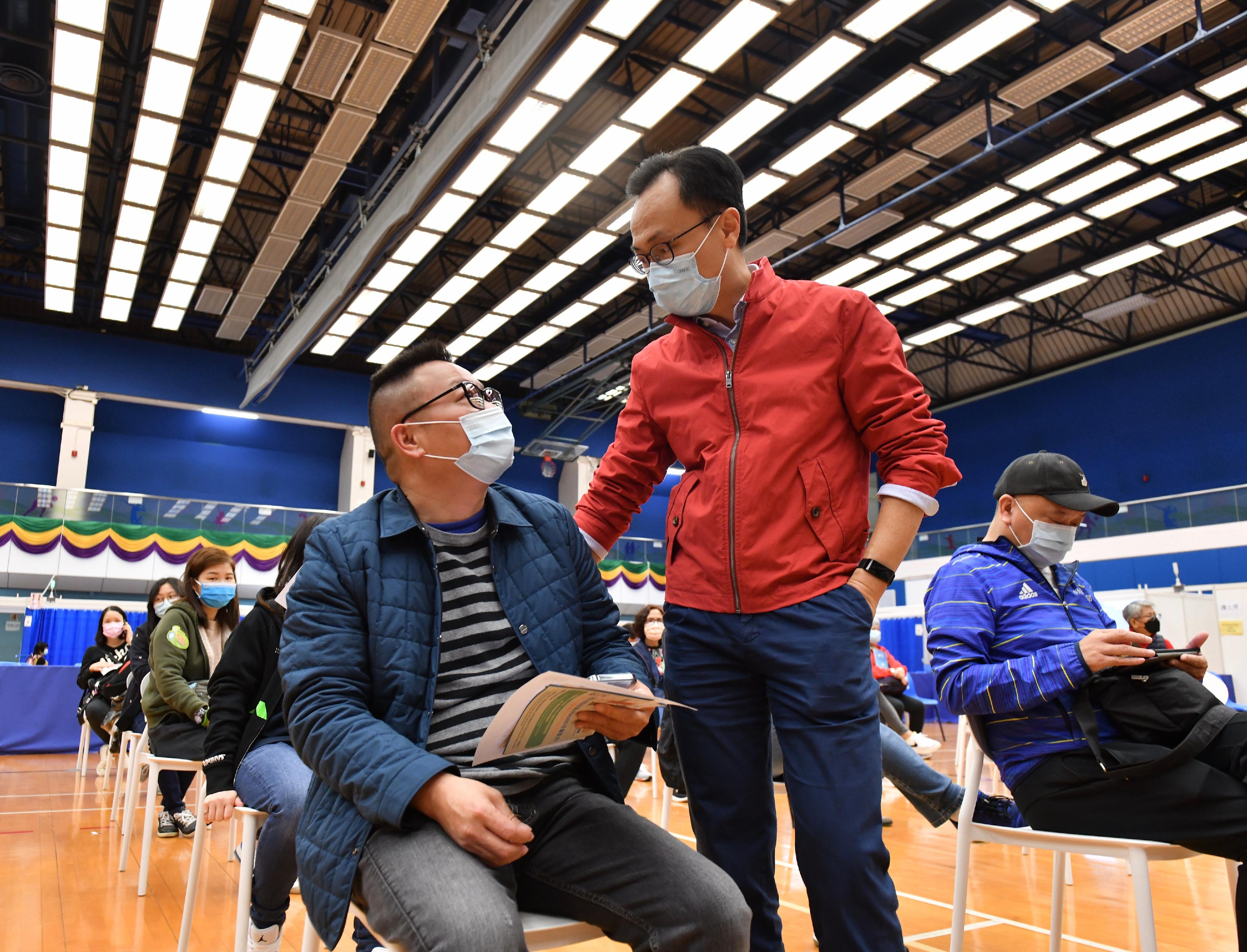 The Secretary for the Civil Service, Mr Patrick Nip, visited the Lai Chi Kok Park Sports Centre today (January 1) to see for himself the first day operation of the Community Vaccination Centre there after the extension of its opening hours. Photo shows Mr Nip (right) chatting with a member of the public after he received his third dose of COVID-19 vaccine.

