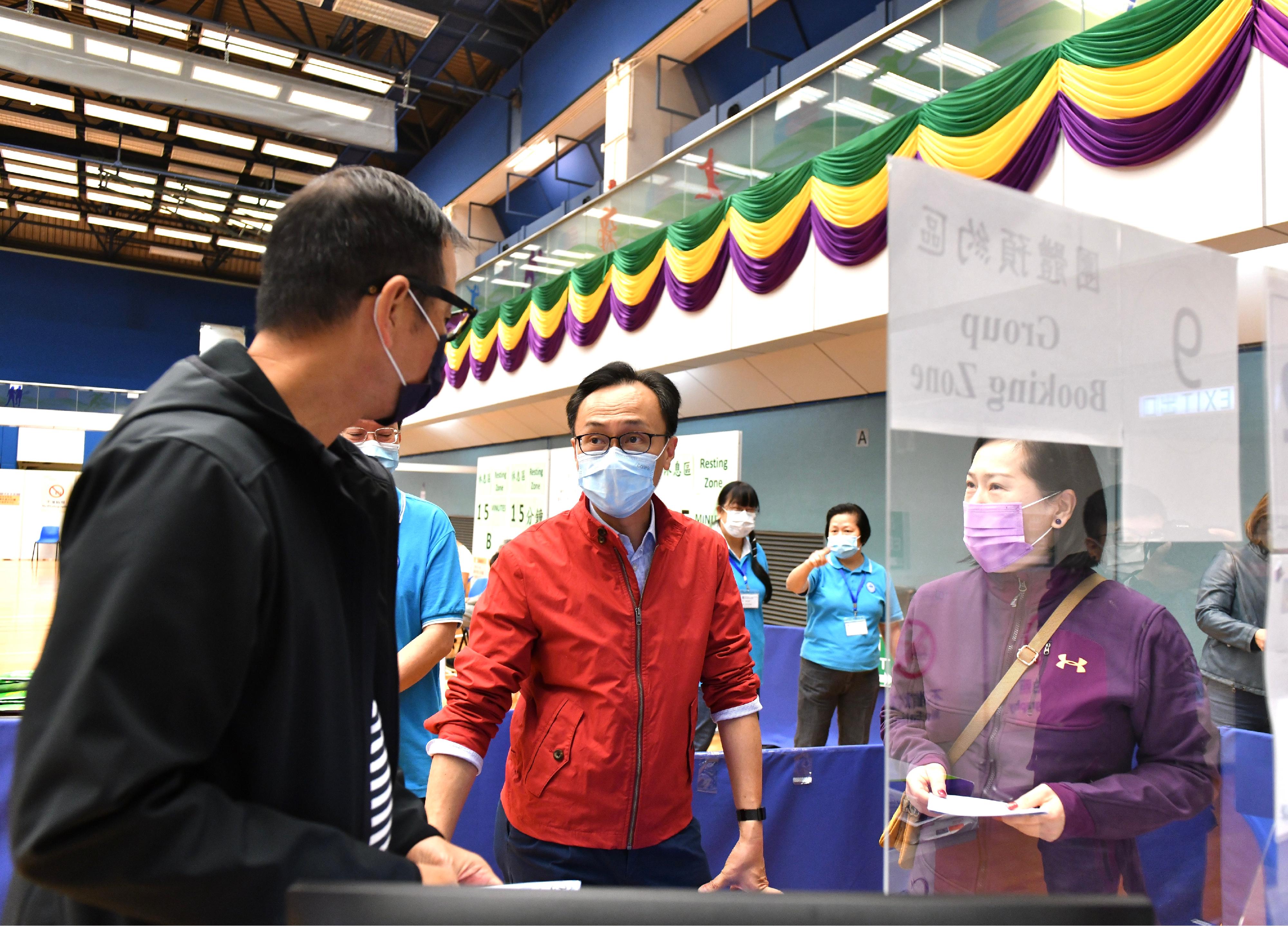 The Secretary for the Civil Service, Mr Patrick Nip, visited the Lai Chi Kok Park Sports Centre today (January 1) to see for himself the first day operation of the Community Vaccination Centre there after the extension of its opening hours and to appeal to the public to get vaccinated as early as possible. Photo shows Mr Nip (centre) chatting with members of the public who will receive COVID-19 vaccination there.

