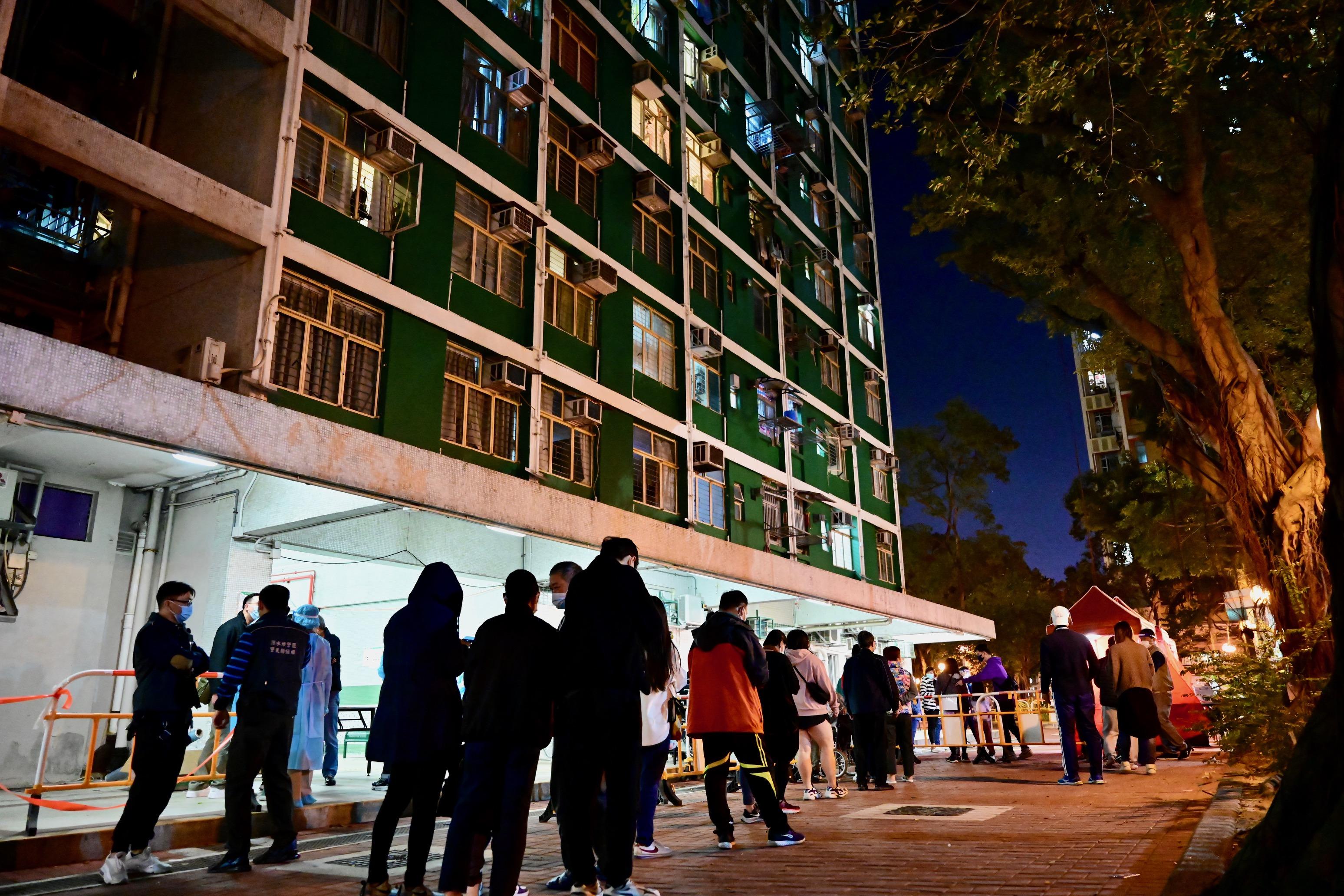 The Government yesterday (January 15) made a "restriction-testing declaration" and issued a compulsory testing notice in respect of the specified "restricted area" in Sham Shui Po (i.e. Tung Moon House, Tai Hang Tung Estate, 83 Tai Hang Tung Road, Sham Shui Po), under which people within the specified "restricted area" in Sham Shui Po were required to stay in their premises and undergo compulsory testing. Photo shows staff members of the Housing Department assisting the affected persons to register for testing.
