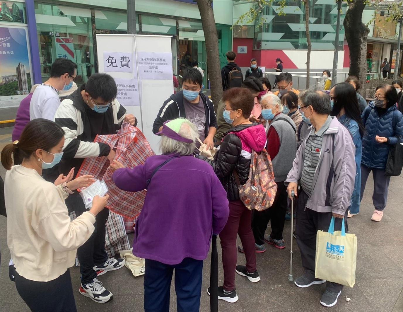 The Home Affairs Department and the Sham Shui Po District Office (SSPDO) has launched a number of measures in Sham Shui Po district to support residents fighting against the disease. Photo shows staff of the SSPDO distributing complimentary COVID-19 rapid testing kits to residents in Sham Shui Po district today (January 20).