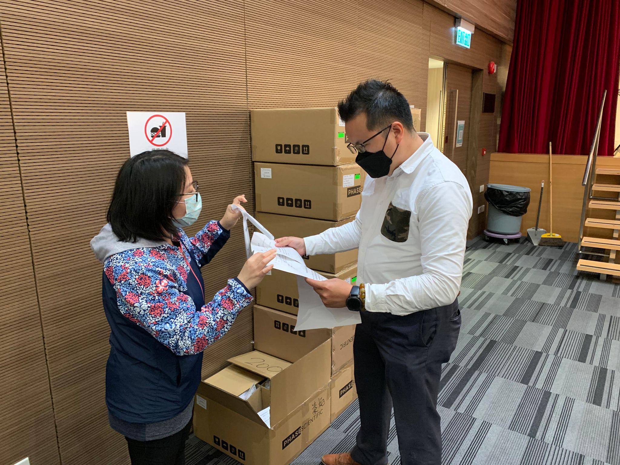 Yuen Long District Office distributes boxes of rapid test kits to property management companies within the area concerned for testing by the residents today (January 28).